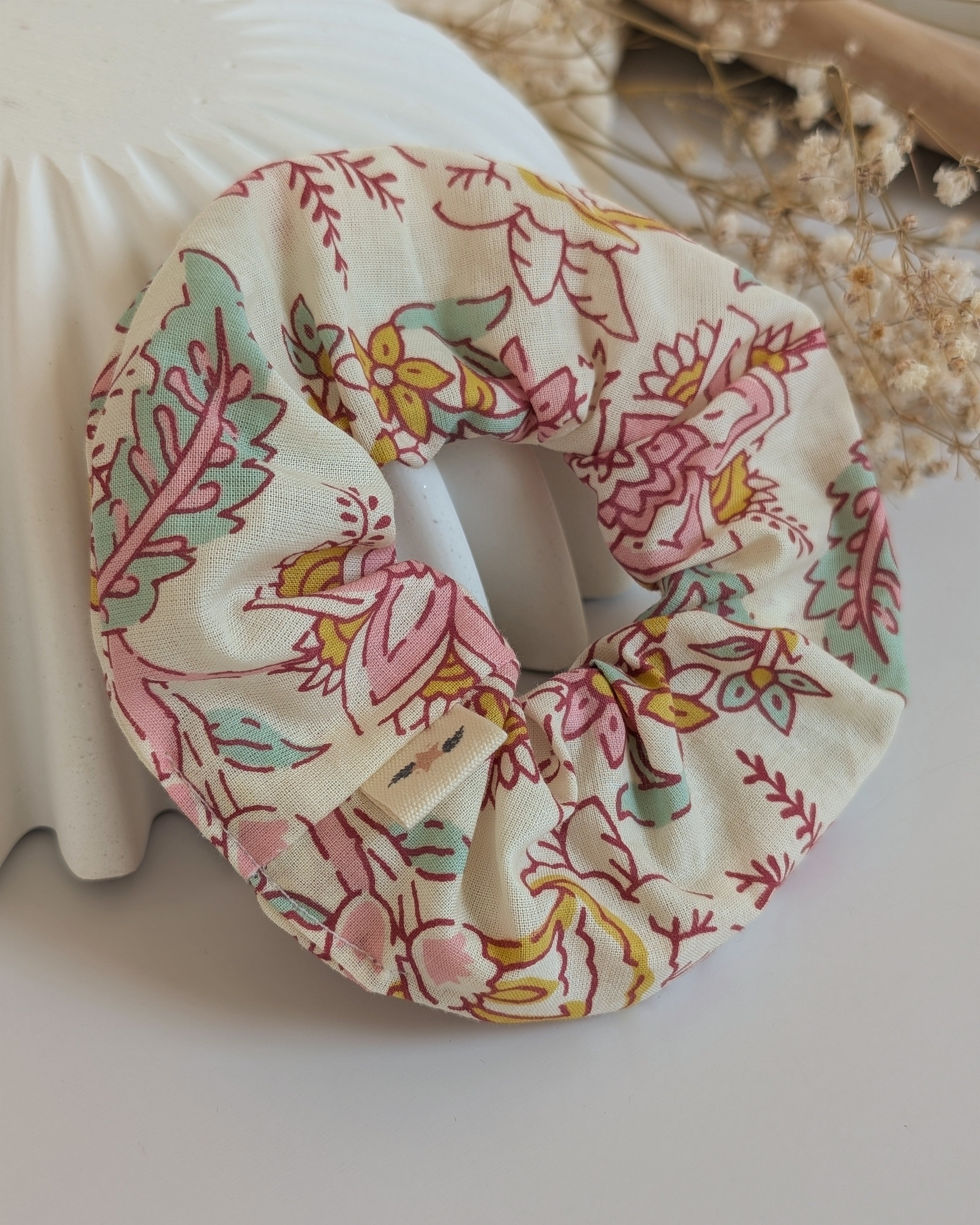 Chouchou imprimé floral indien pastel posé sur coupelle striée. Cousu main La Tête dans les nétoiles