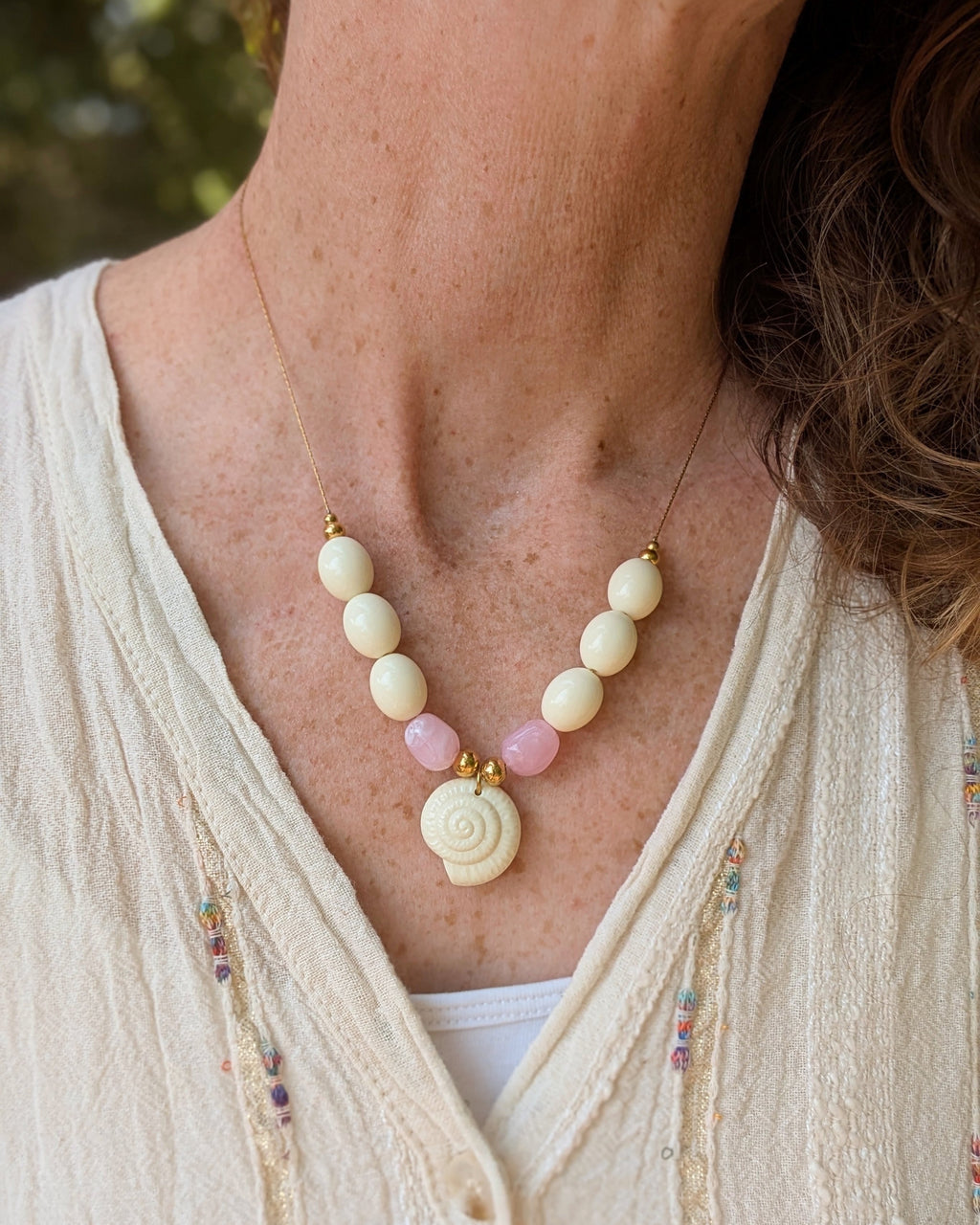 Collier Azura porté par une femme avec une robe en lin. Création artisanale La Tête dans les Nétoiles 