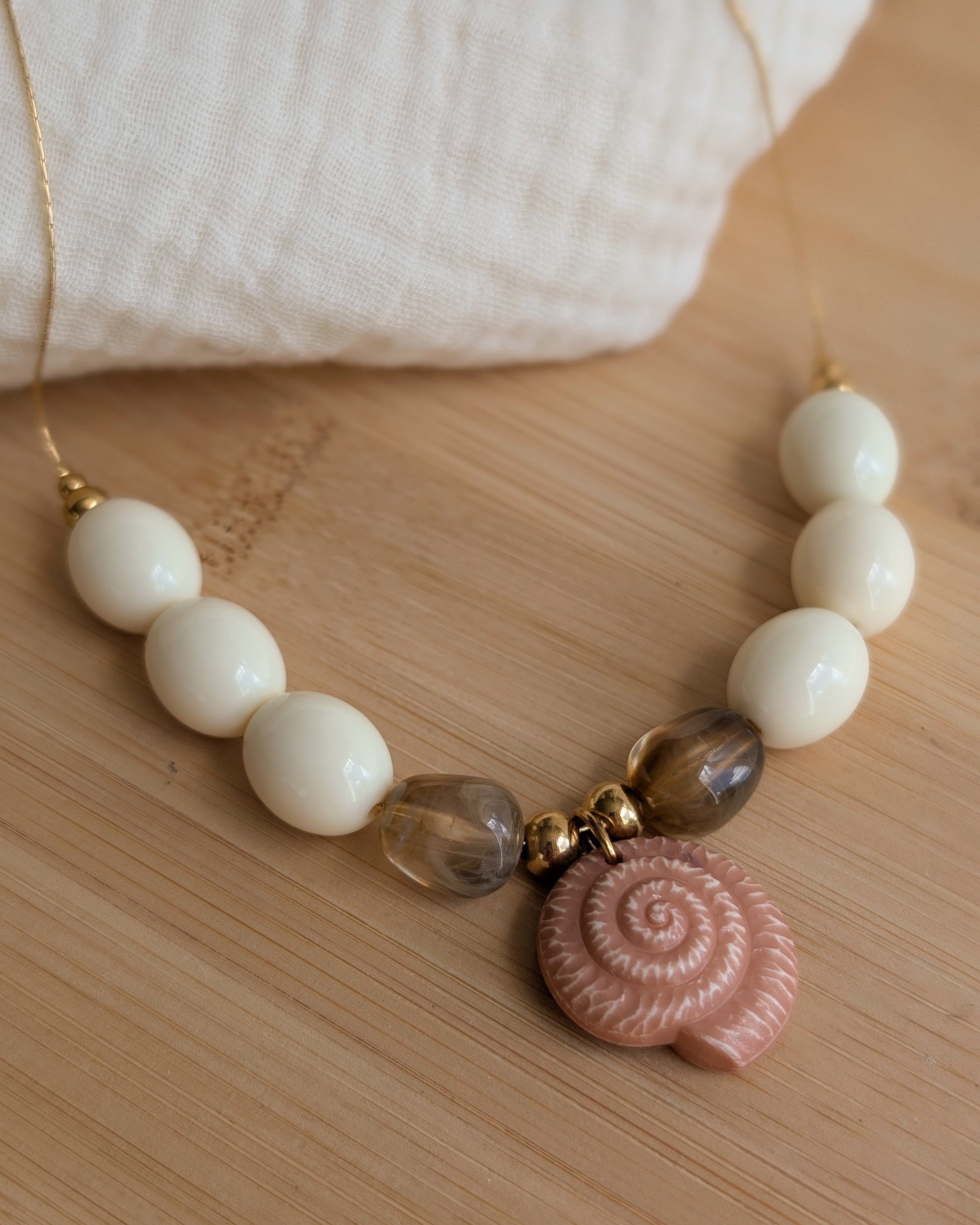 Collier Azura perles crème et marron et ammonite marron clair. 
Création artisanale La Tête dans les Nétoiles 