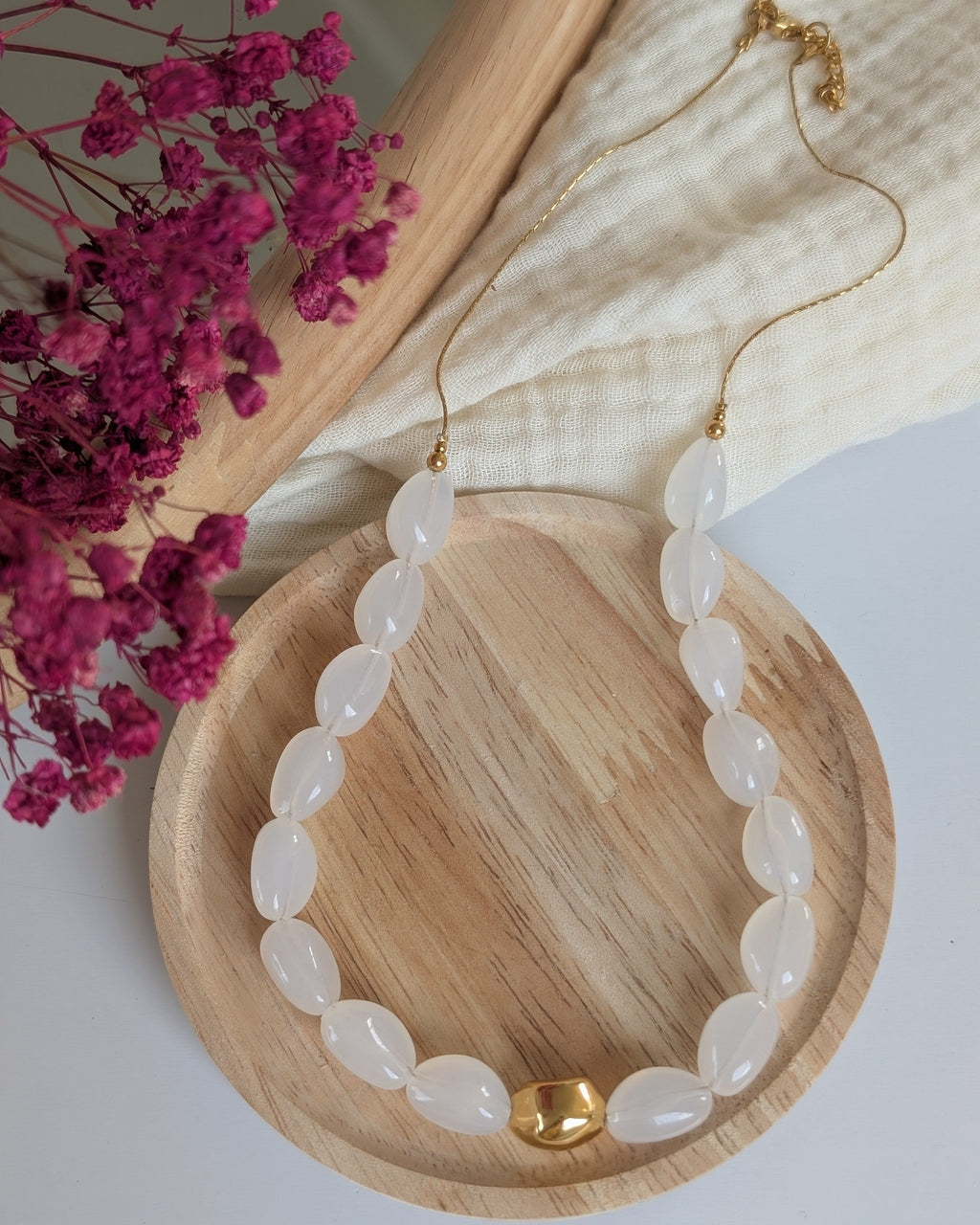 Collier Louison coloris blanc Opale en vue entière. Posé sur rondin en bois. Création fait main La Tête dans les nétoiles