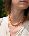 Collier Louison perle ambre solaire porté par une femme. Création La Tête dans les Nétoiles