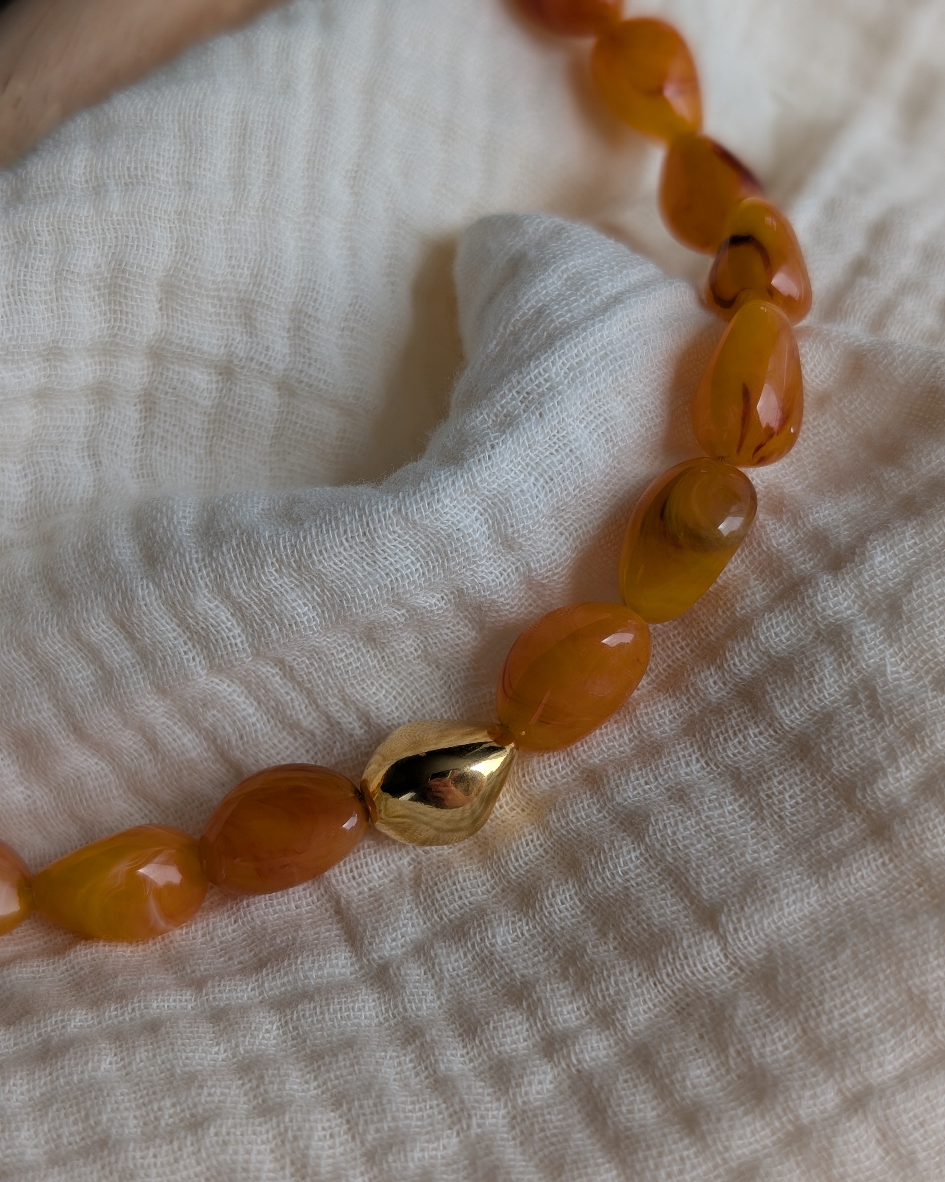 collier Louison abricot ambre photo prise en gros plan. Création La Tête dans les nétoiles
