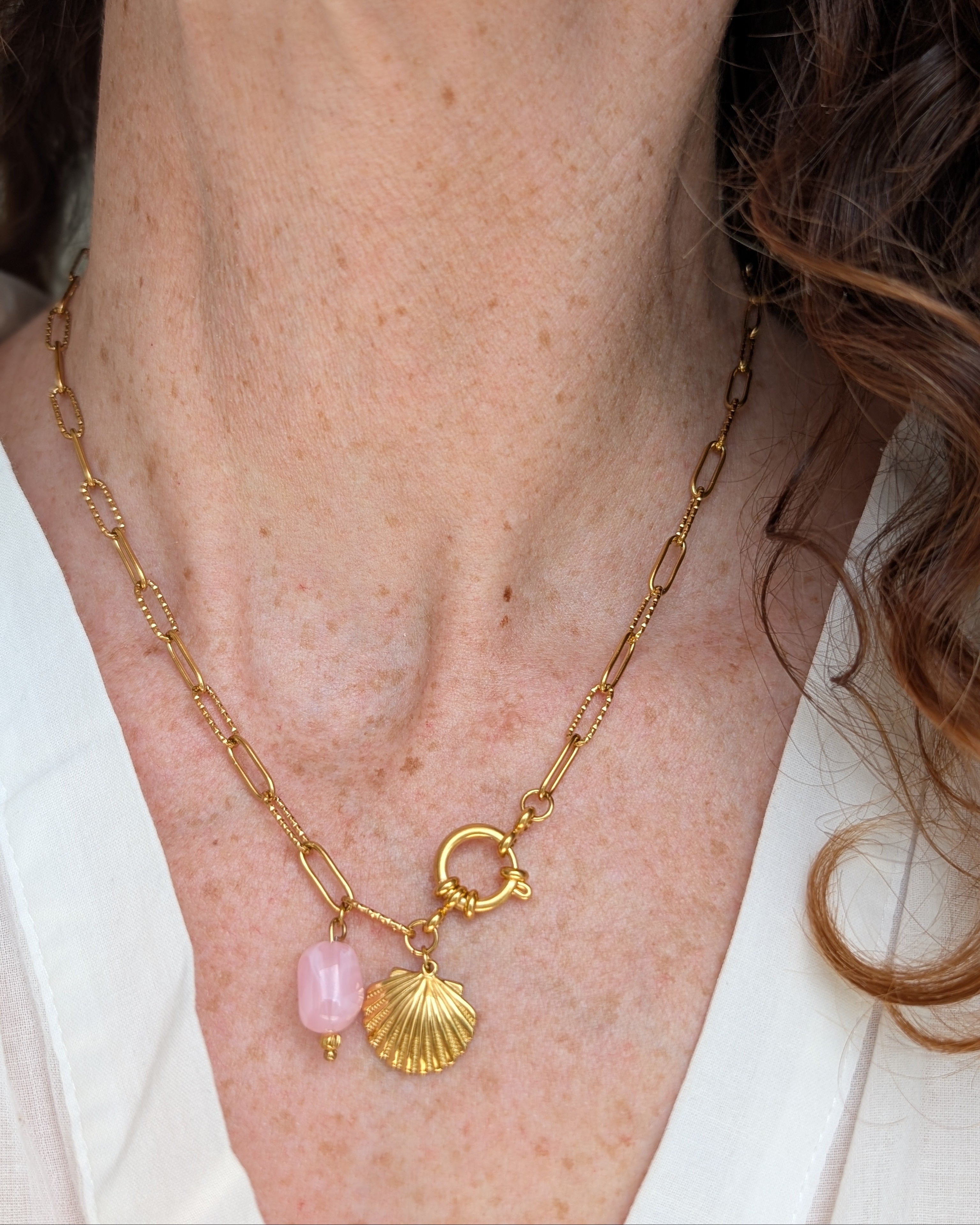 collier Nahée chaine maille trombone avec pendentif coquillage et perle rose poudré porté par une femme. Créations artisanales La Tête dans les nétoiles