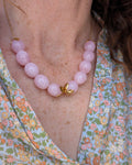 collier Olivia perles ovales en résine rose poudré marbré porté par une femme. Créations artisanales La Tête dans les Nétoiles