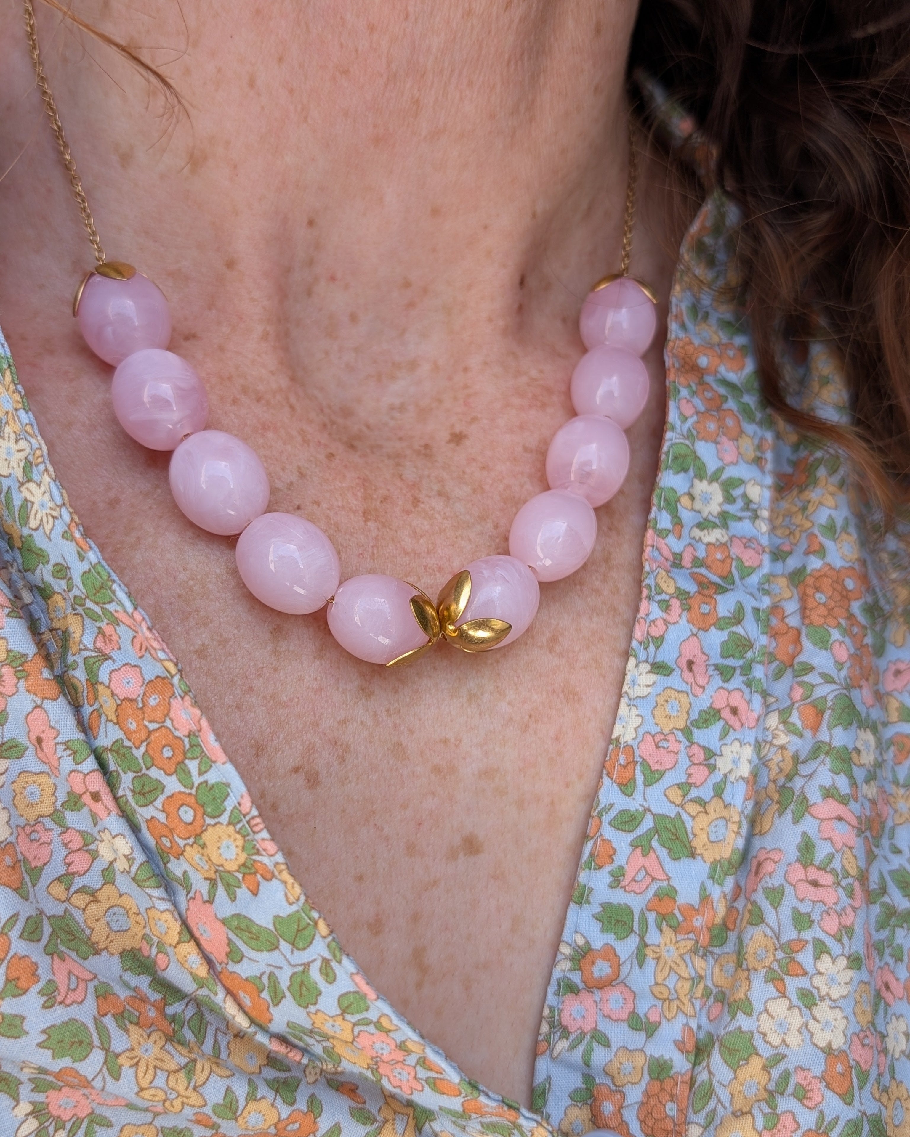 collier Olivia perles ovales en résine rose poudré marbré porté par une femme. Créations artisanales La Tête dans les Nétoiles