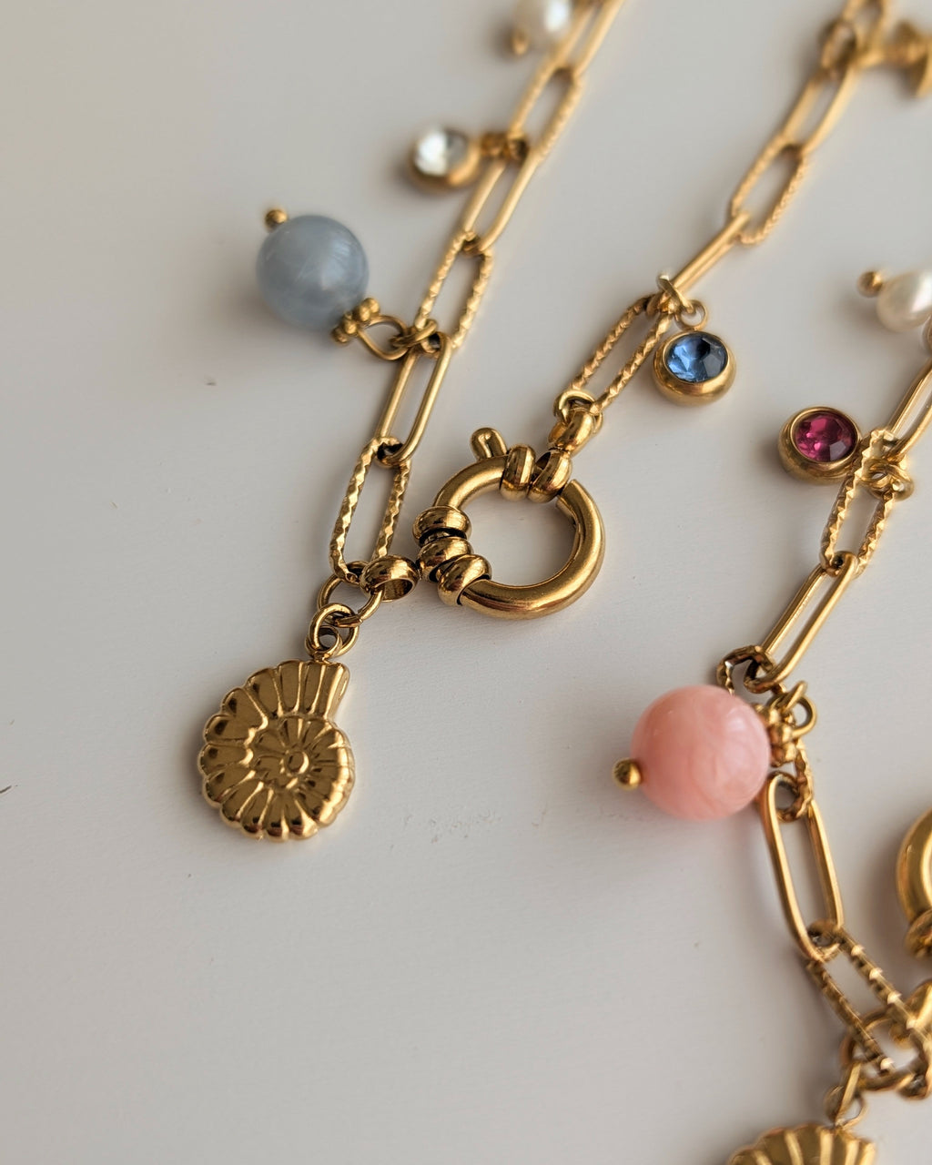 Gros plan sur le collier Océane zoom sur le pendentif ammonite et le fermoir boué. Collier charms en acier inoxydable doré. Créations artisanales La Tête dans les Nétoiles