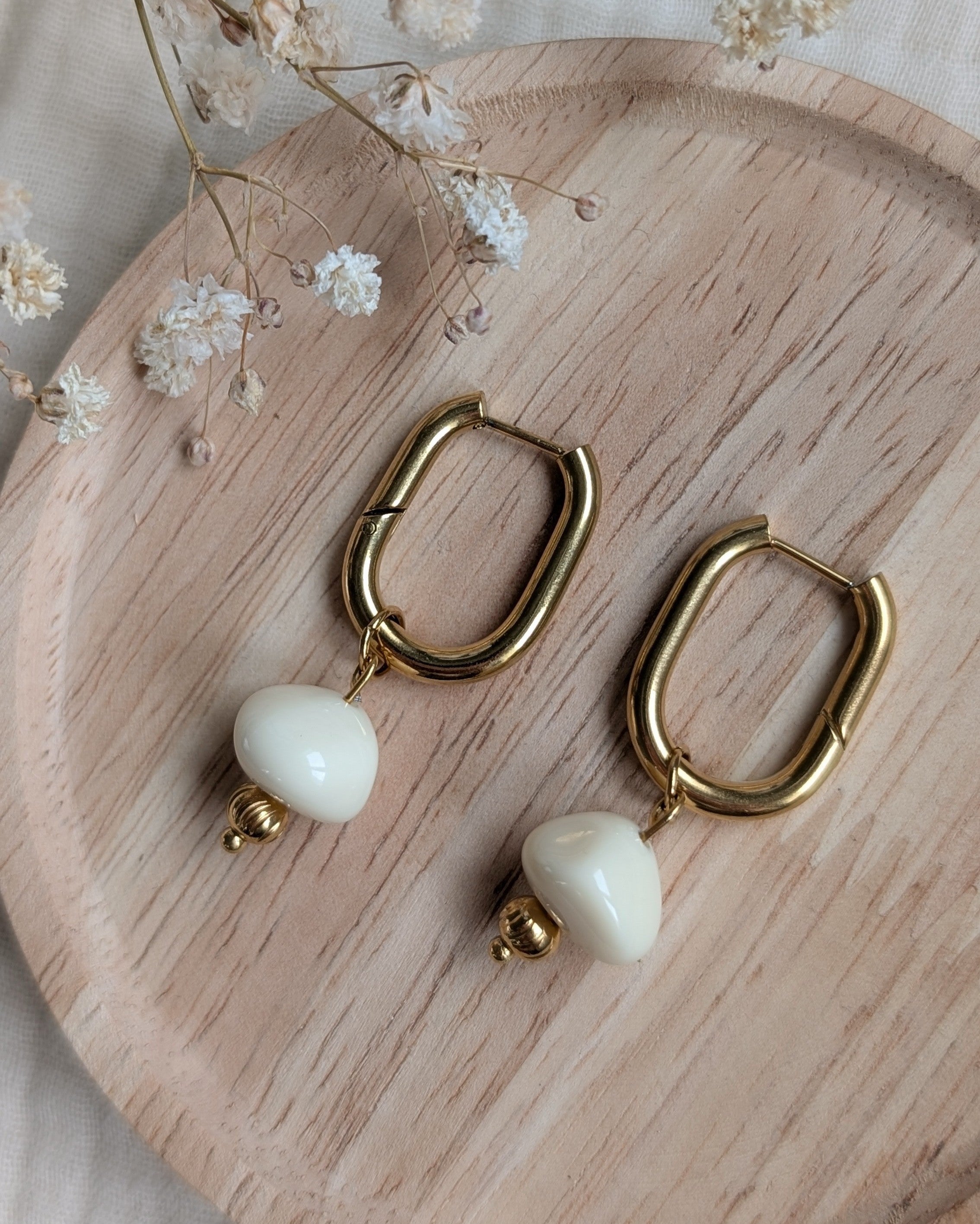 Paire de créoles ovales en acier inoxydable doré et perle résine ivoire. Création artisanale La Tête dans les Nétoiles