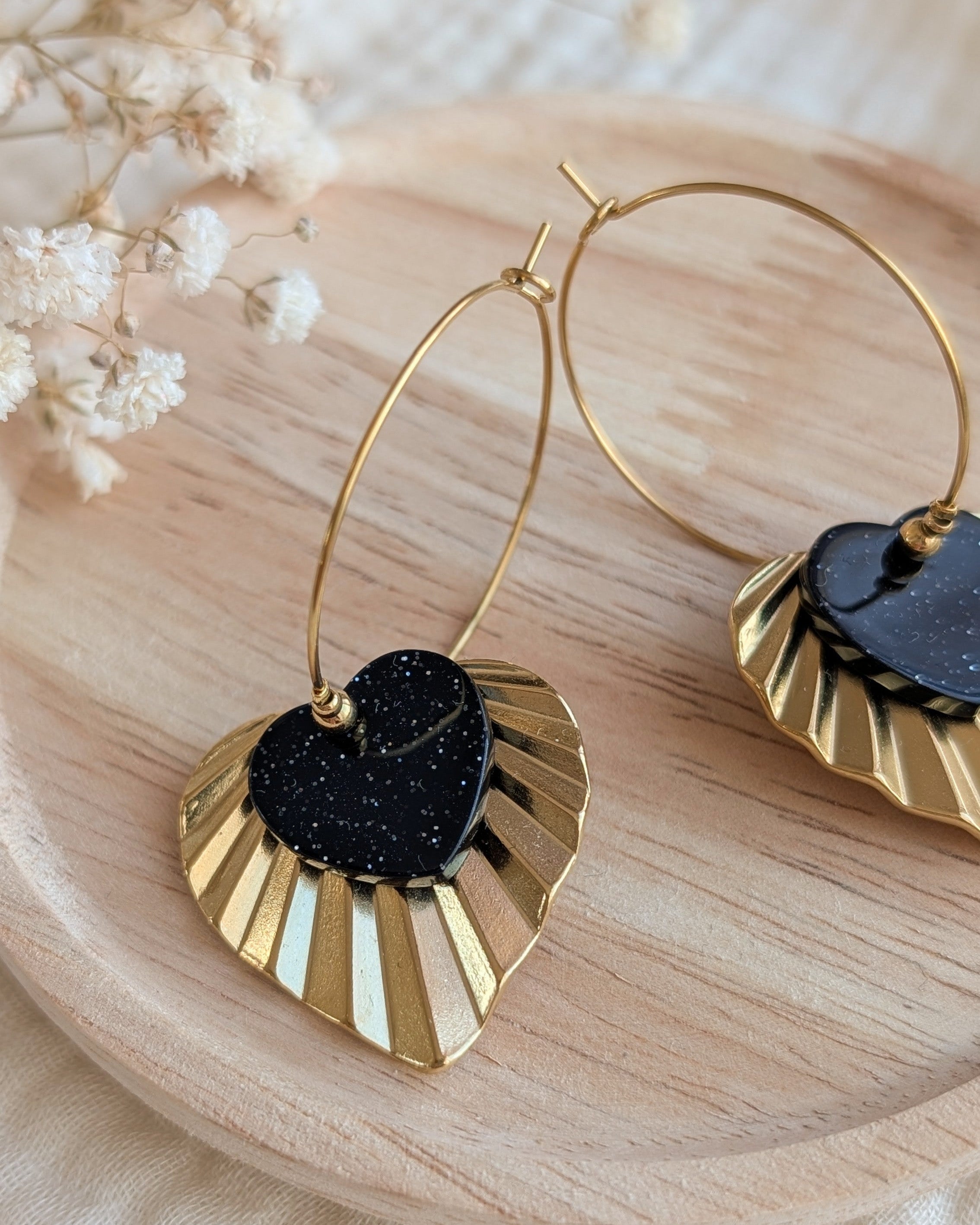Créaoles Alma avec coeur en acrylique noir à paillettes et coeur strié acier inoxydable doré création artisanale La Tête dans les Nétoiles