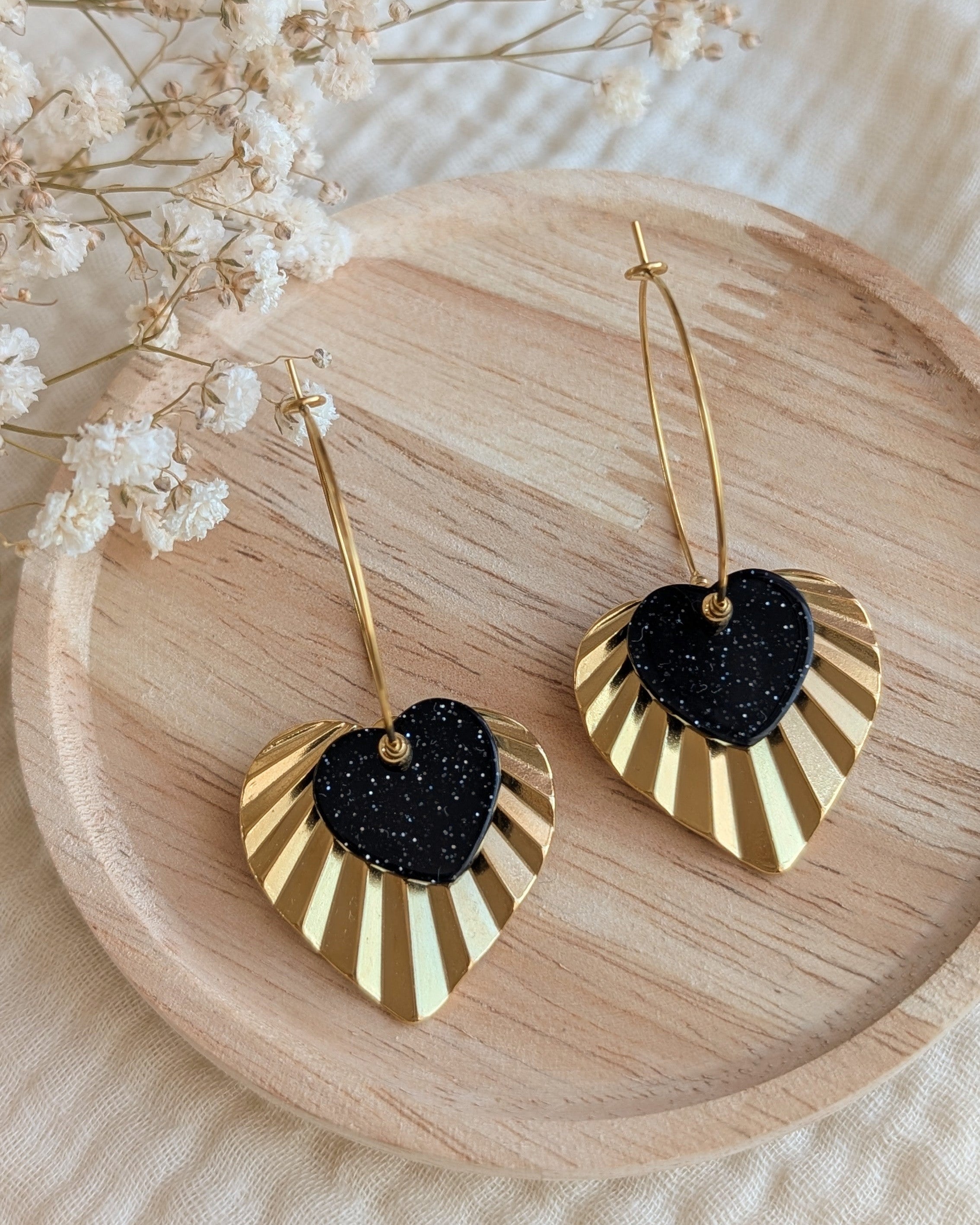 Créoles coeur ALMA coeur paillettes en gros plan sur support en bois coeur en acier inoxydable doré création artisanale La Tête dans les Nétoiles