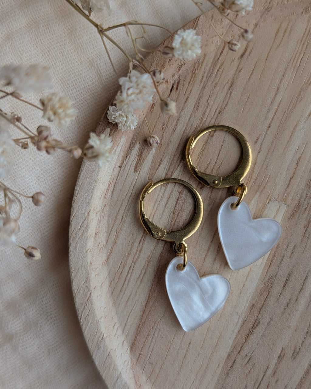 Détail des boucles d'oreilles petites filles cœur blanc nacré. Création artisanale La Tête dans les Nétoiles