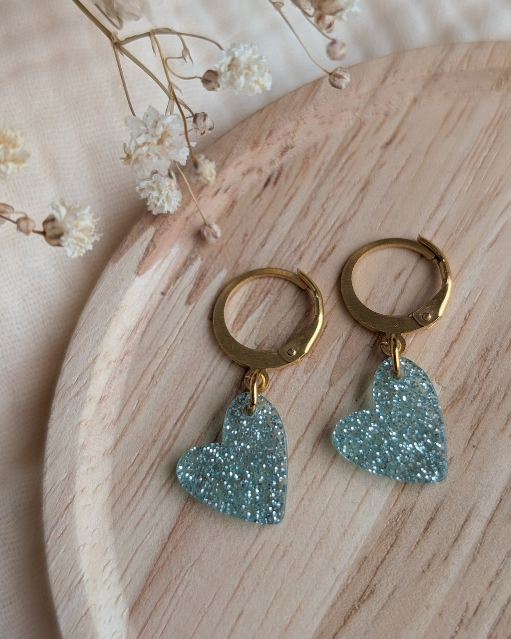 Détail des boucles d'oreilles petites filles cœur bleu ciel pailleté. Création artisanale La Tête dans les Nétoiles