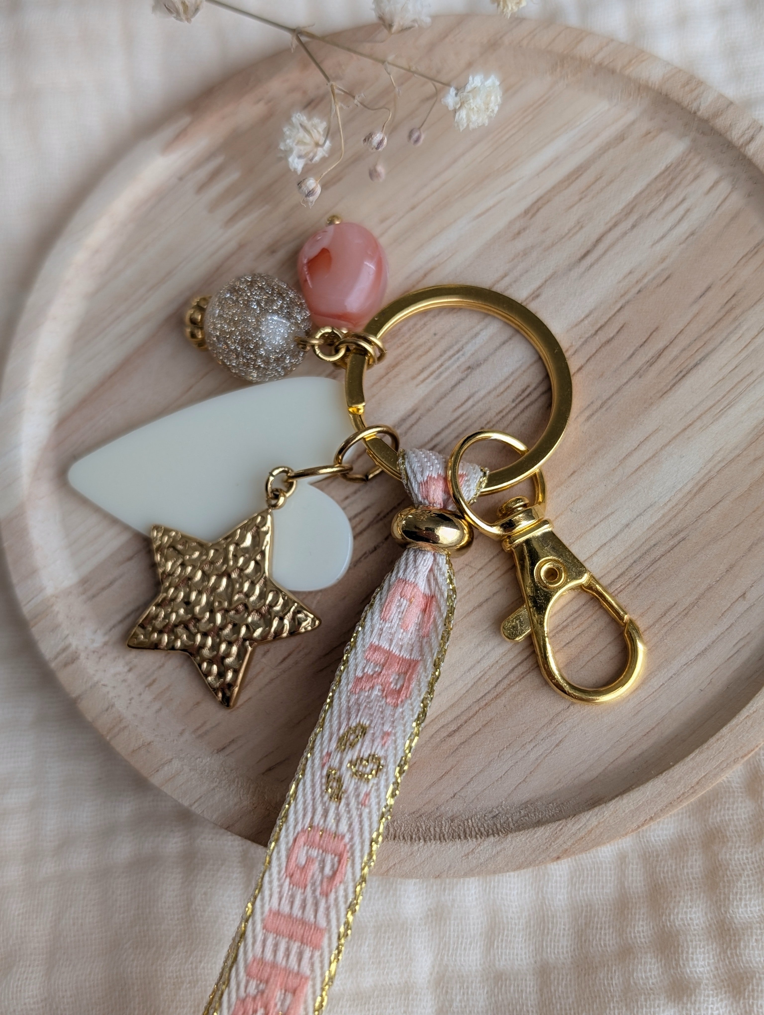 Details porte clés bijoux de sac perle champagne dore et rose résine mousqueton en acier créations artisanales La Tête dans les Nétoiles