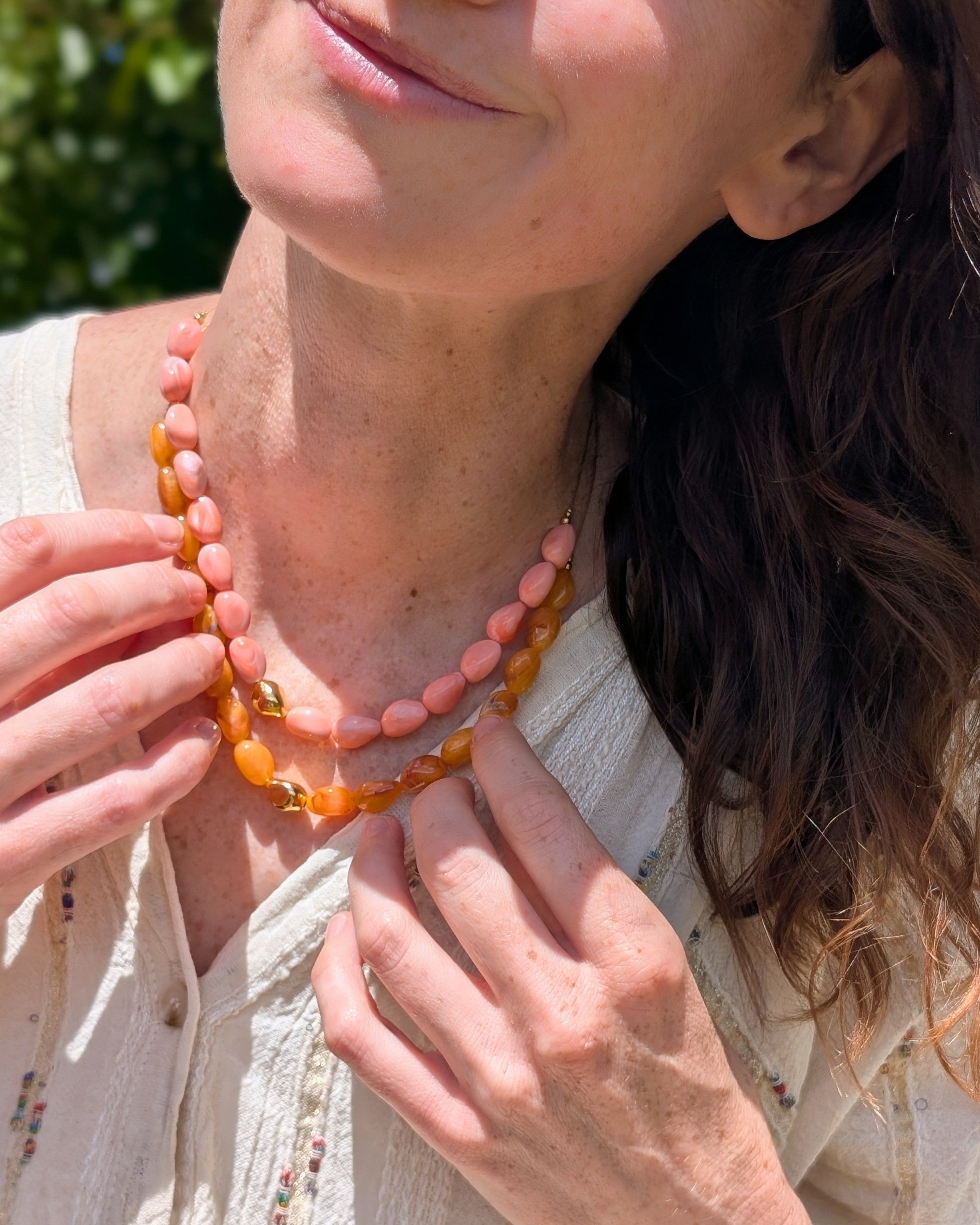 Duo colliers Louison abricot et corail. Portées par une femme. Créations artisanales La Tête dans les Nétoiles 
