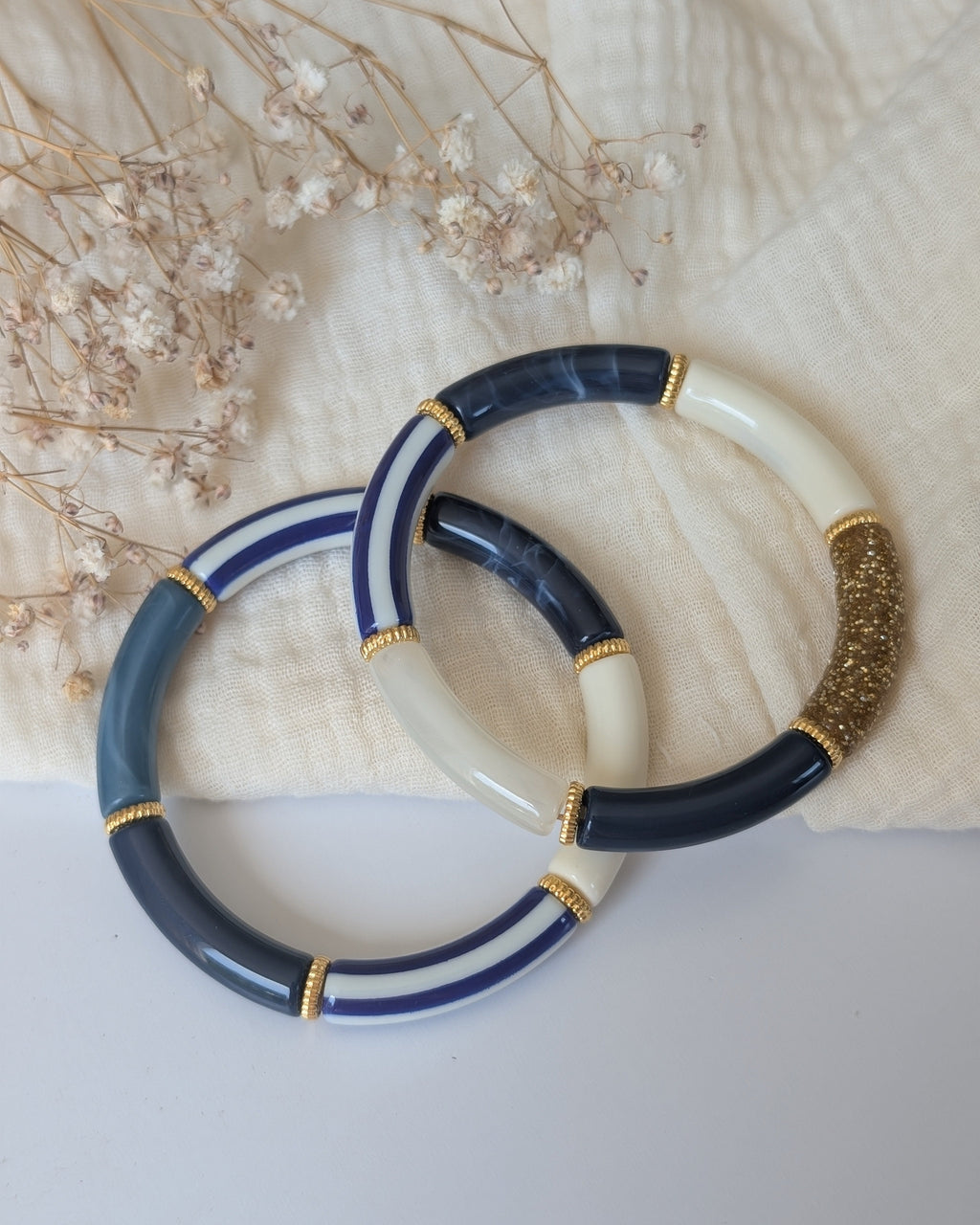 Duo de bracelets perles tube à rayures bleues posées sur gaze de coton. Création artisanale La Tête dans les Nétoiles 