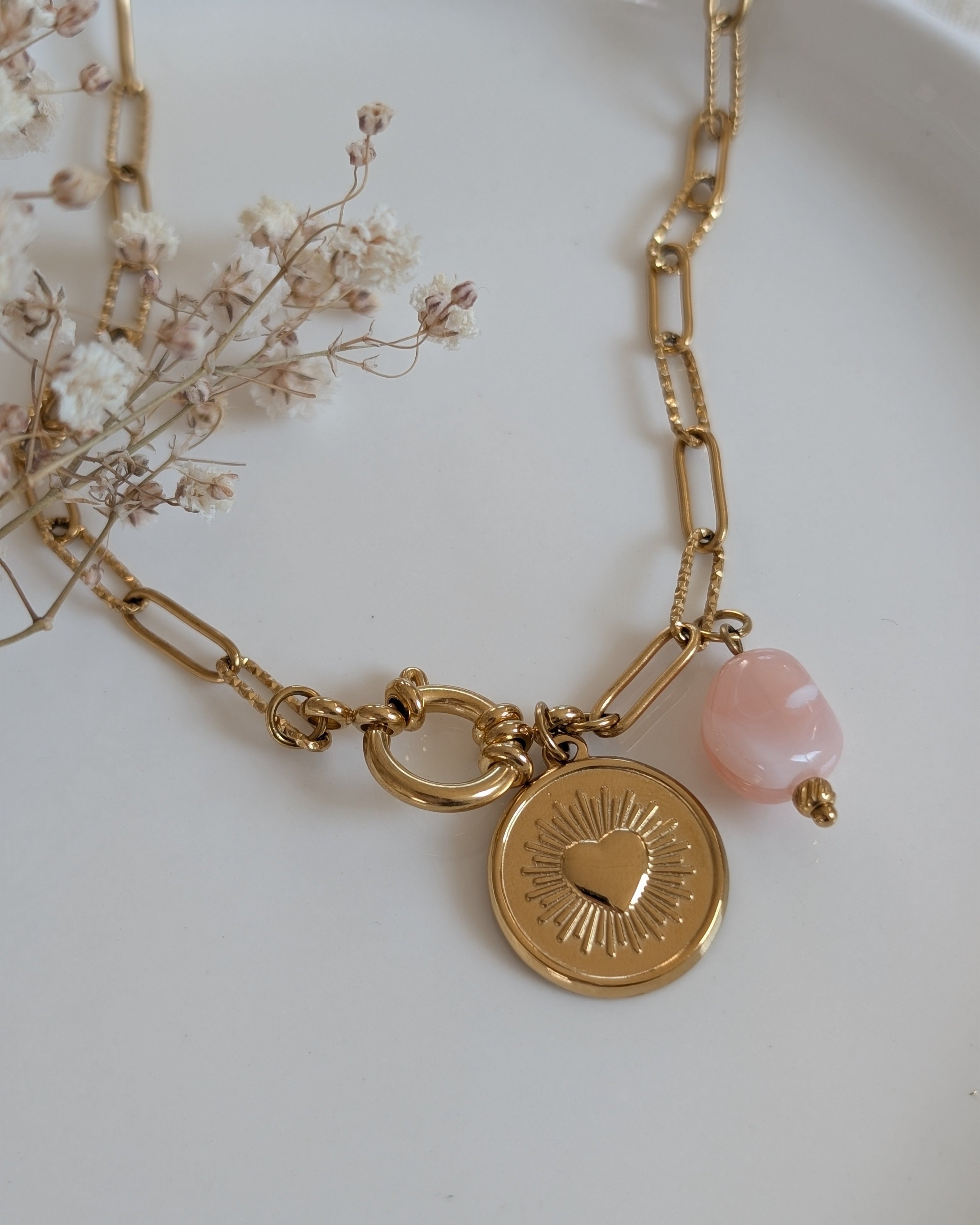 Gros plan sur le collier Nahée pendentif coeur radiant et perles en résine rose. Création La Tête dans les Nétoiles