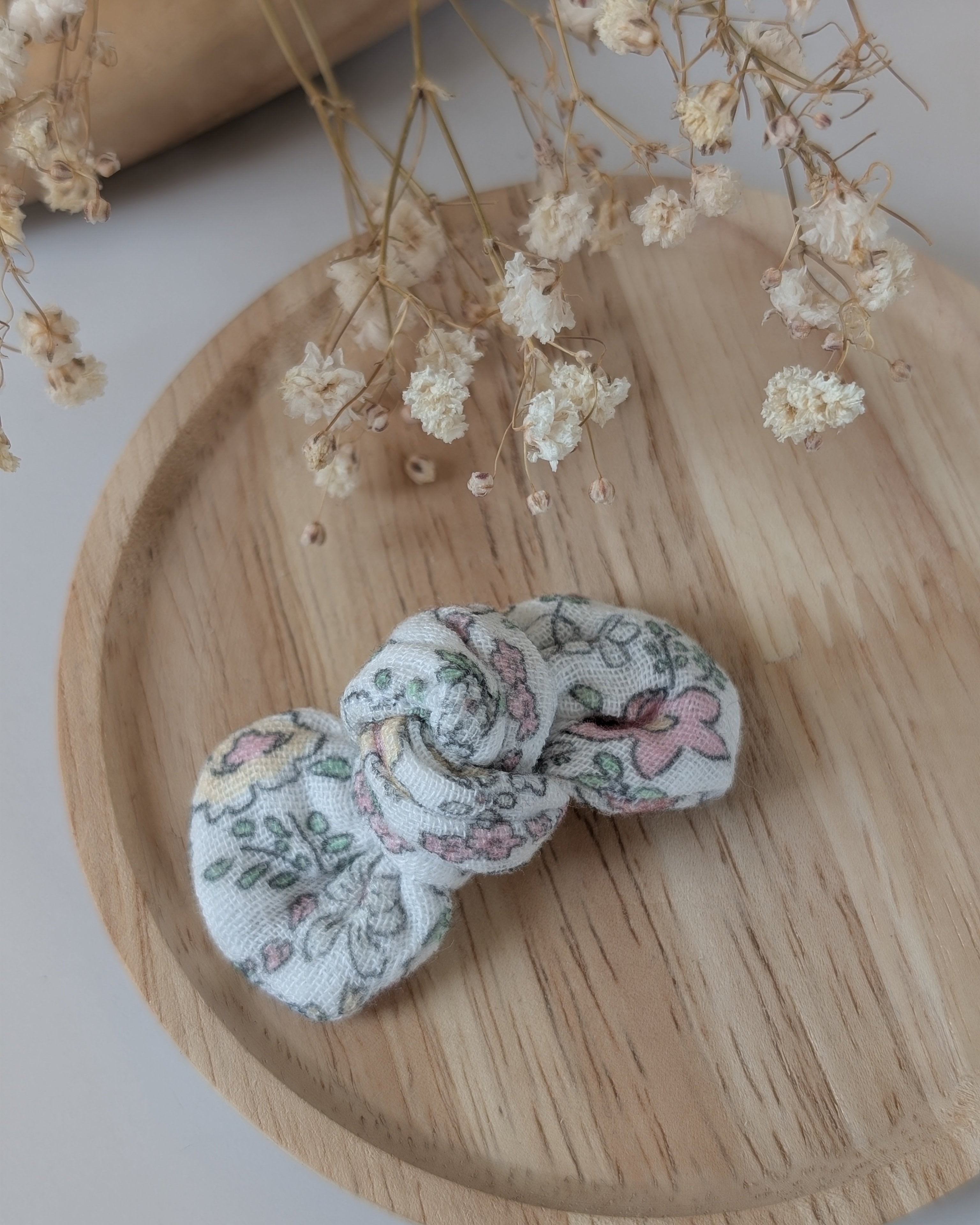 Noeud cheveux en gaze de coton fleuris rose tendre. Cousu main La Tête dans les Nétoiles. Posé sur plateau en bois