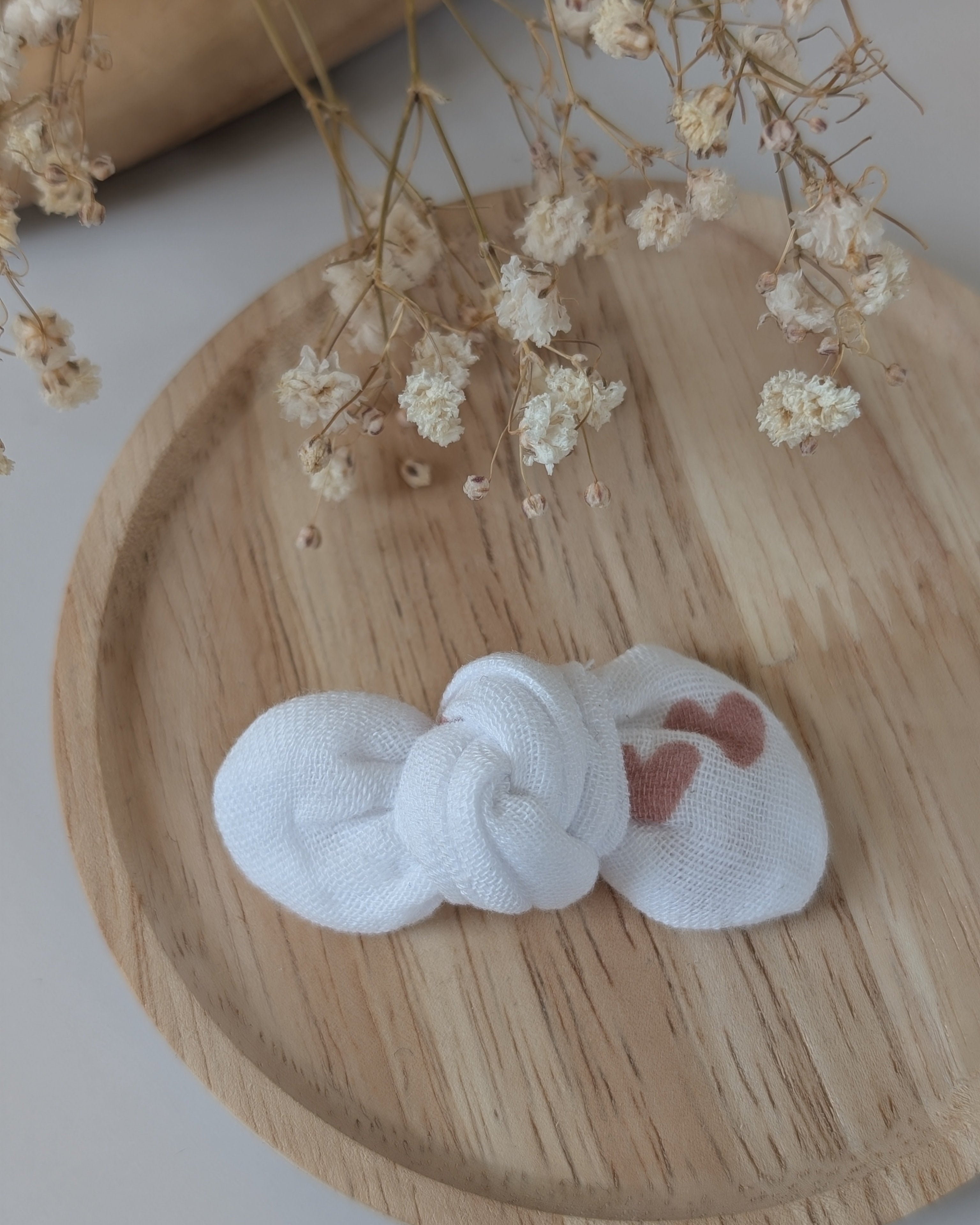 Noeud Romie coeur rose sur fond gaze de coton blanc