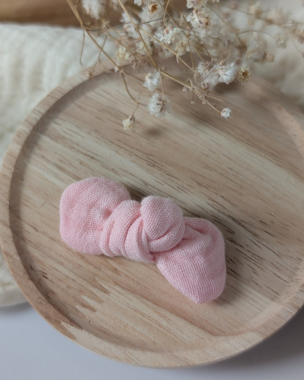 Noeud cheveux bébé fille gaze de coton rose blush cousu main La Tête dans les nétoiles. Posé sur un support en bois