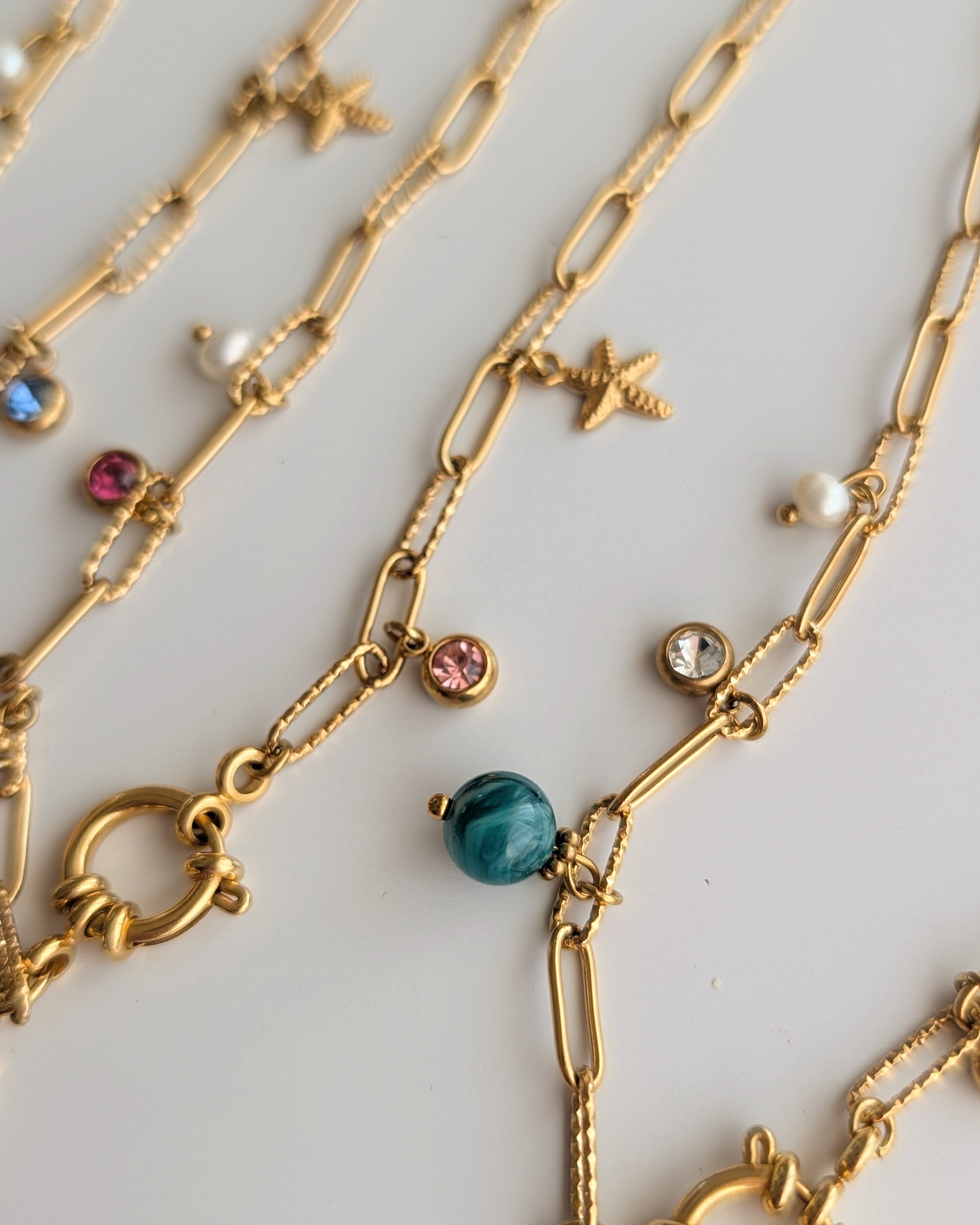 Photo sur les détails breloques charms strass en acier inoxydable doré. Créations artisanales La Tête dans les Nétoiles
