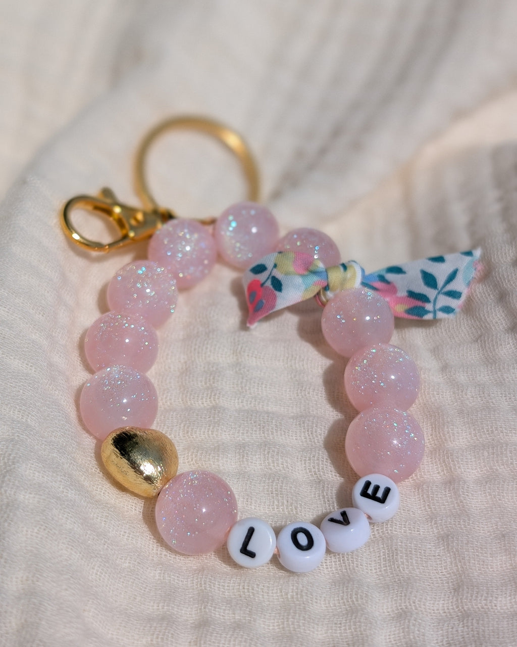 porte clés personnalisable à message perles à paillettes rose  et mot love posé sur gaze de coton. Créations artisanales La Tête dans les Nétoiles