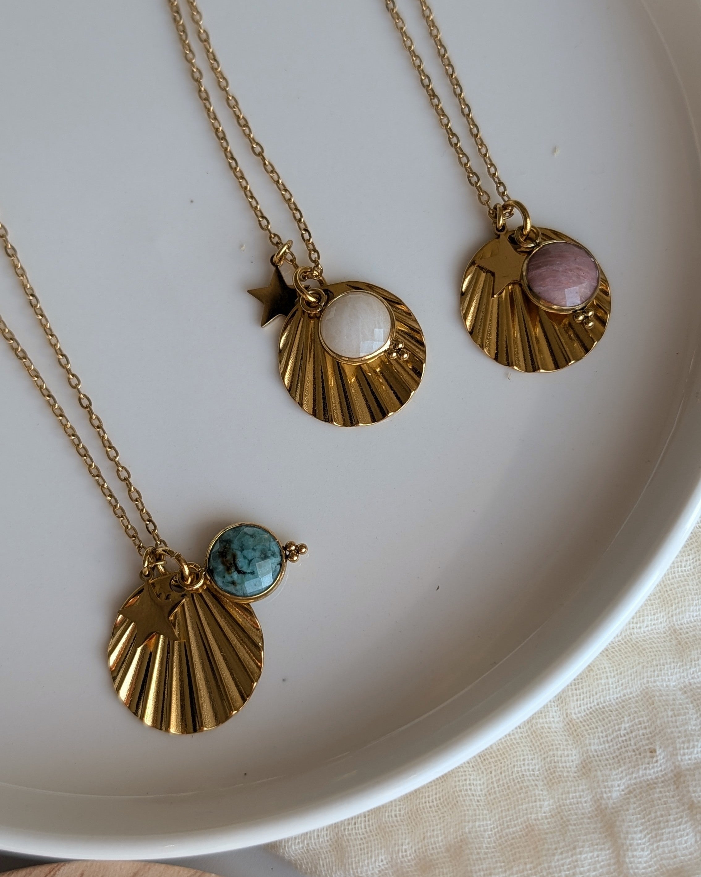 Trio de colliers Anaé . Pierre de lune, africaine turquoise et rhodonite rose. Posés sur une coupelle. Créations La Tête dans les Nétoiles