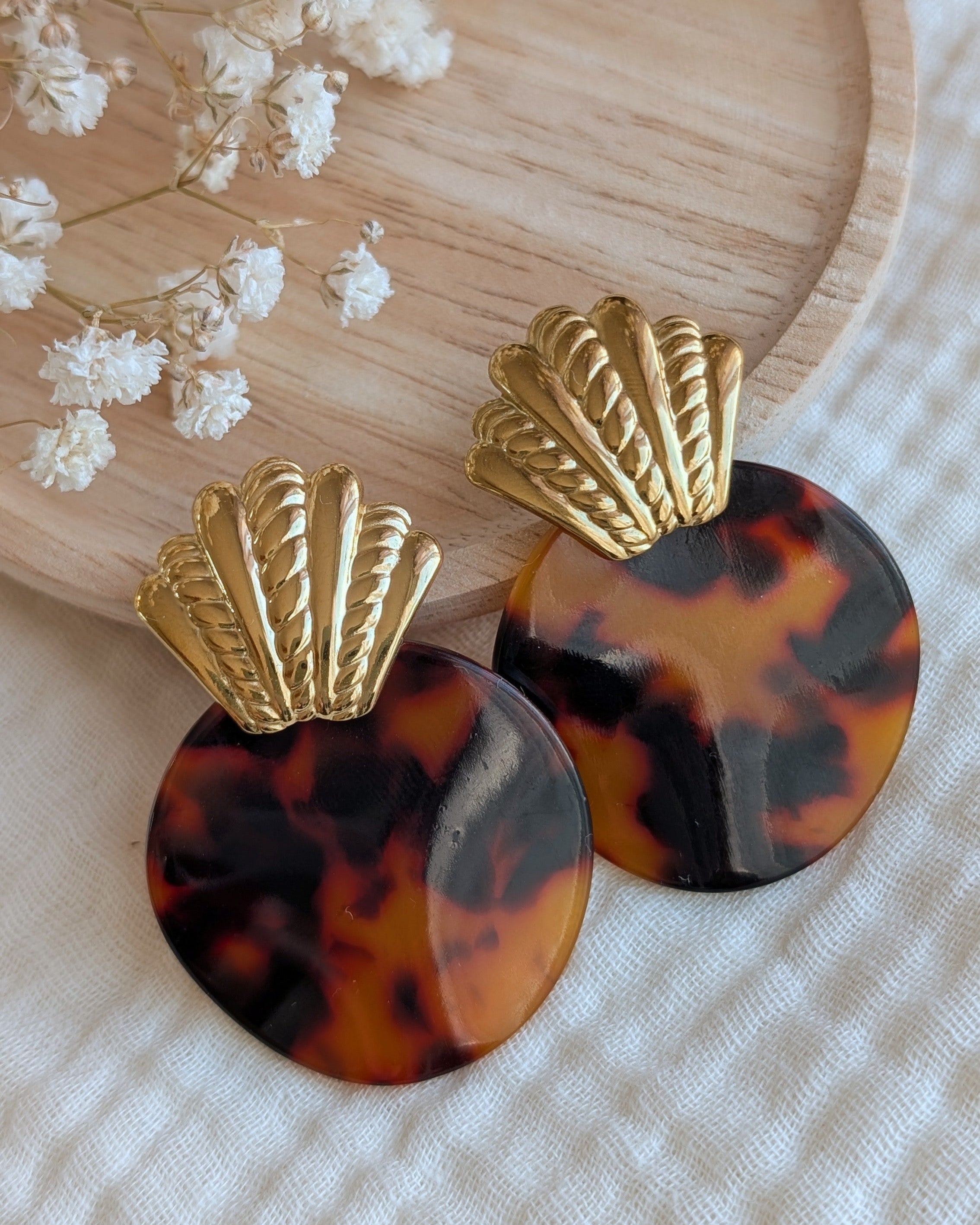 boucles MARTHE coquillage acier inoxydable doré et acétate de cellulose tortoise prise sur support en bois et en fond gypsophile. Créations artisanales La tête dans les Nétoiles