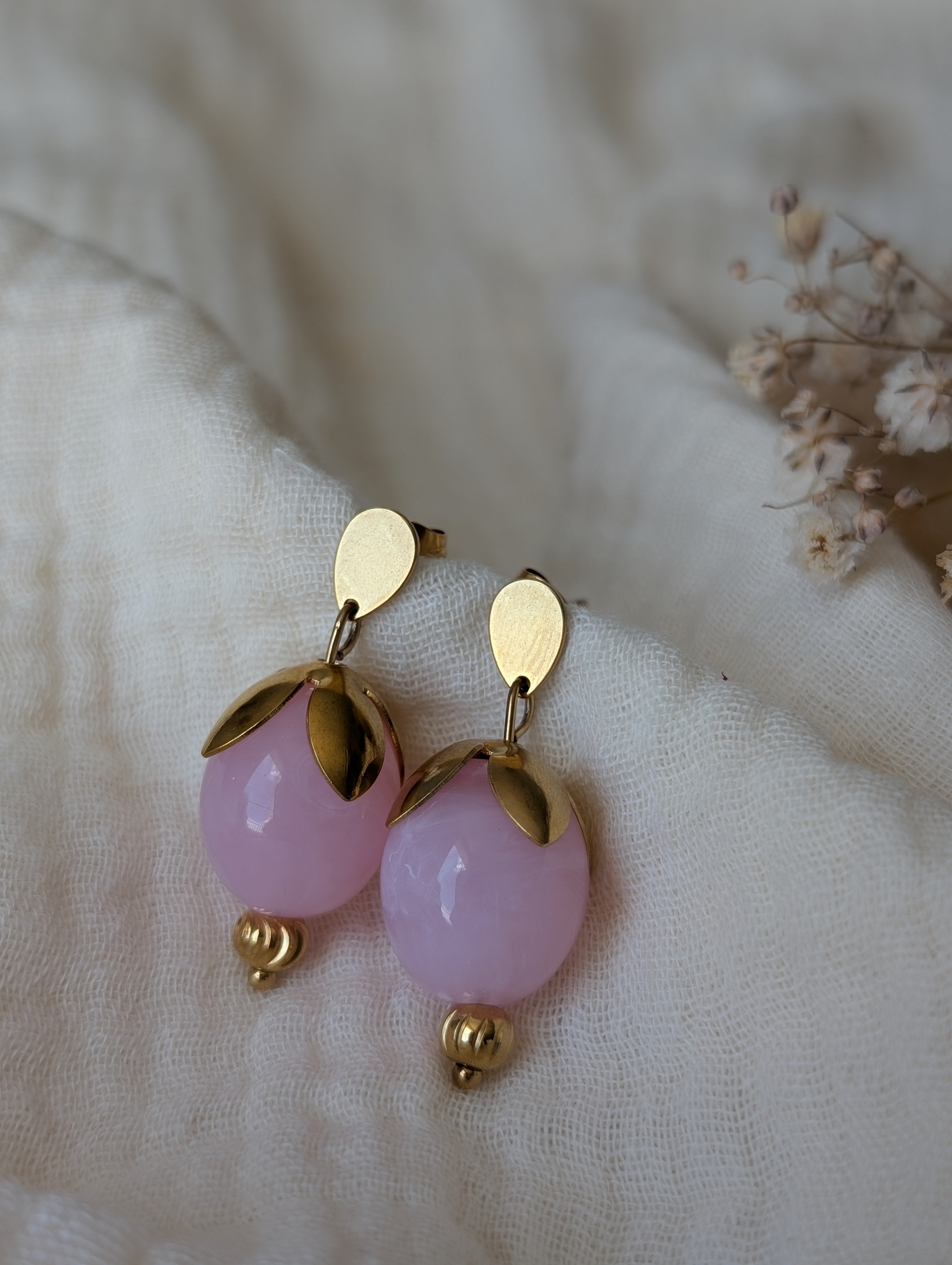 Boucles d'oreilles Olivia perles Olive en résine rose poudré et acier inoxydable doré. En forme de bourgeon. Posées sur gaze de coton. Créations artisanales La Tête dans les nétoiles
