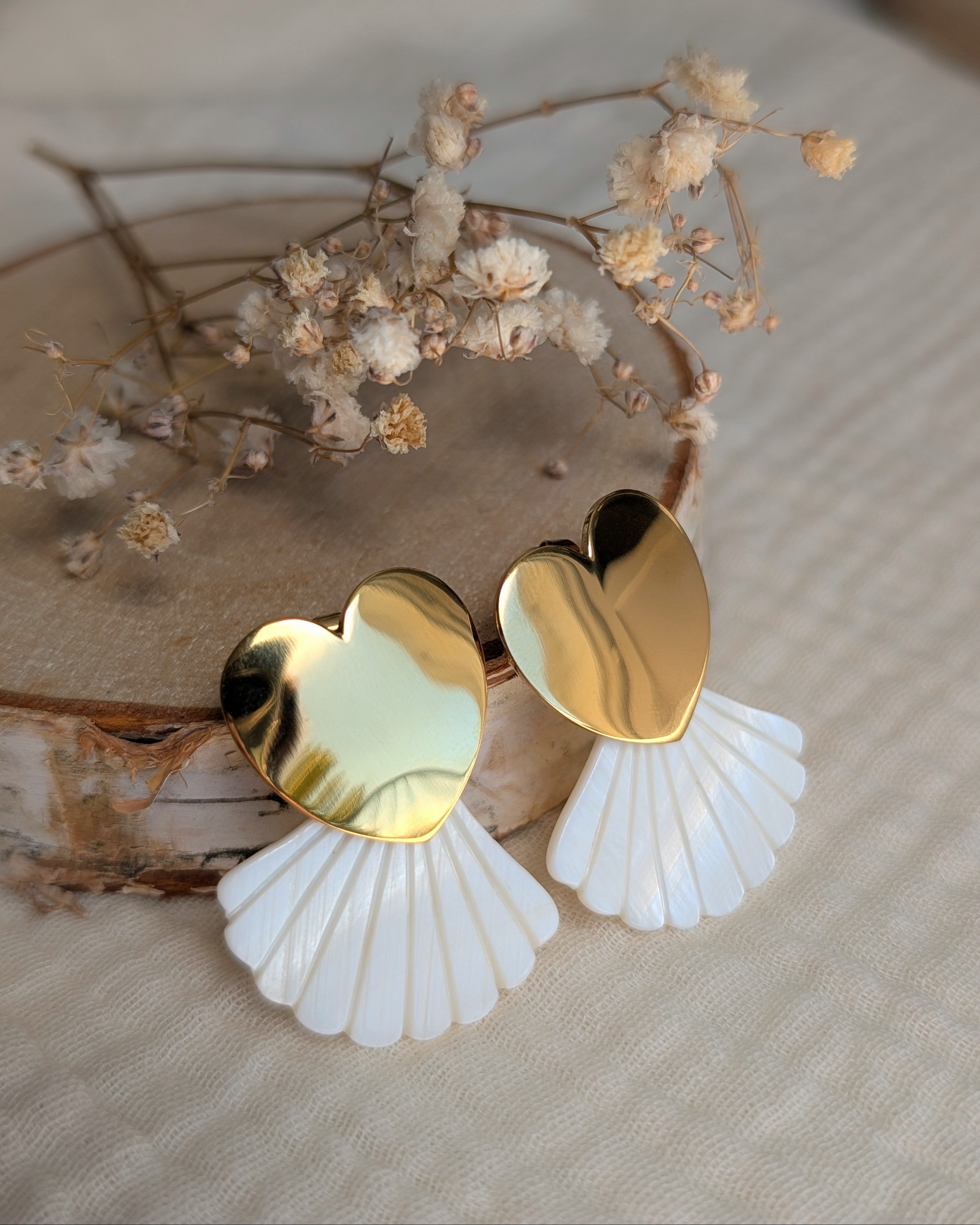 Boucles coeur doré et éventail nacre posées sur gaze de coton et rondin de bois. Créations artisanales La Tête dans les Nétoiles