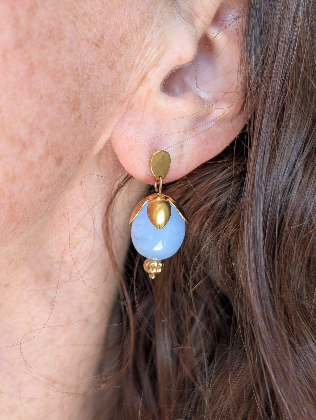 Boucles d'oreilles en forme de bourgeon perles olive bleu azur en résine et acier inoxydable. Portées par une femme. Créations artisanales La Tête dans les nétoiles