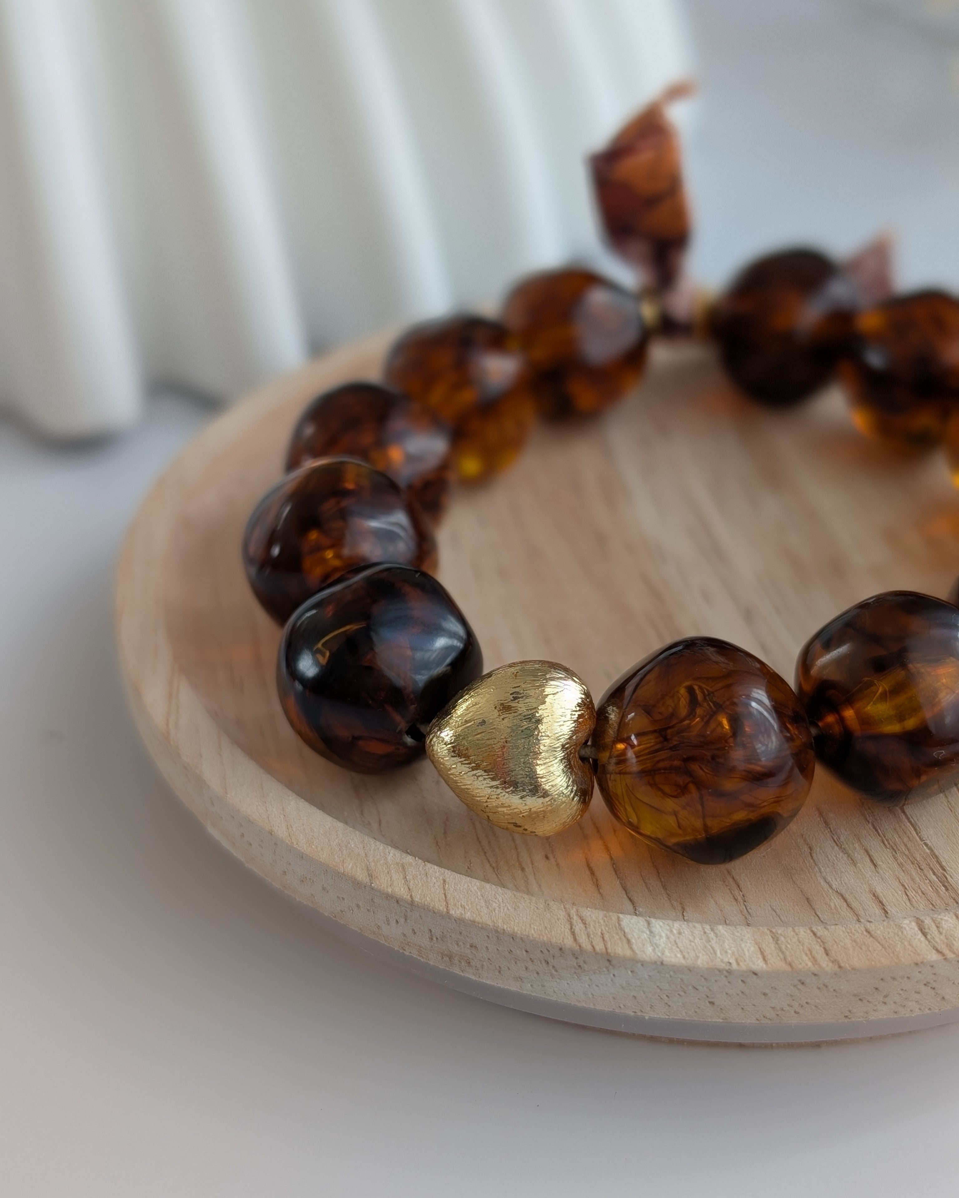 bracelet Adèle perle résine caramel et gros plan sur la perle coeur doré brossé. Créations faits main La Tête dans les Nétoiles