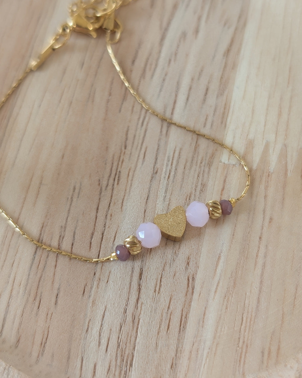 Bracelet fin en maille serpentine en acier inoxydable doré et perle coeur diamantée. Coloris rose et violine. Création La Tête dans les Nétoiles