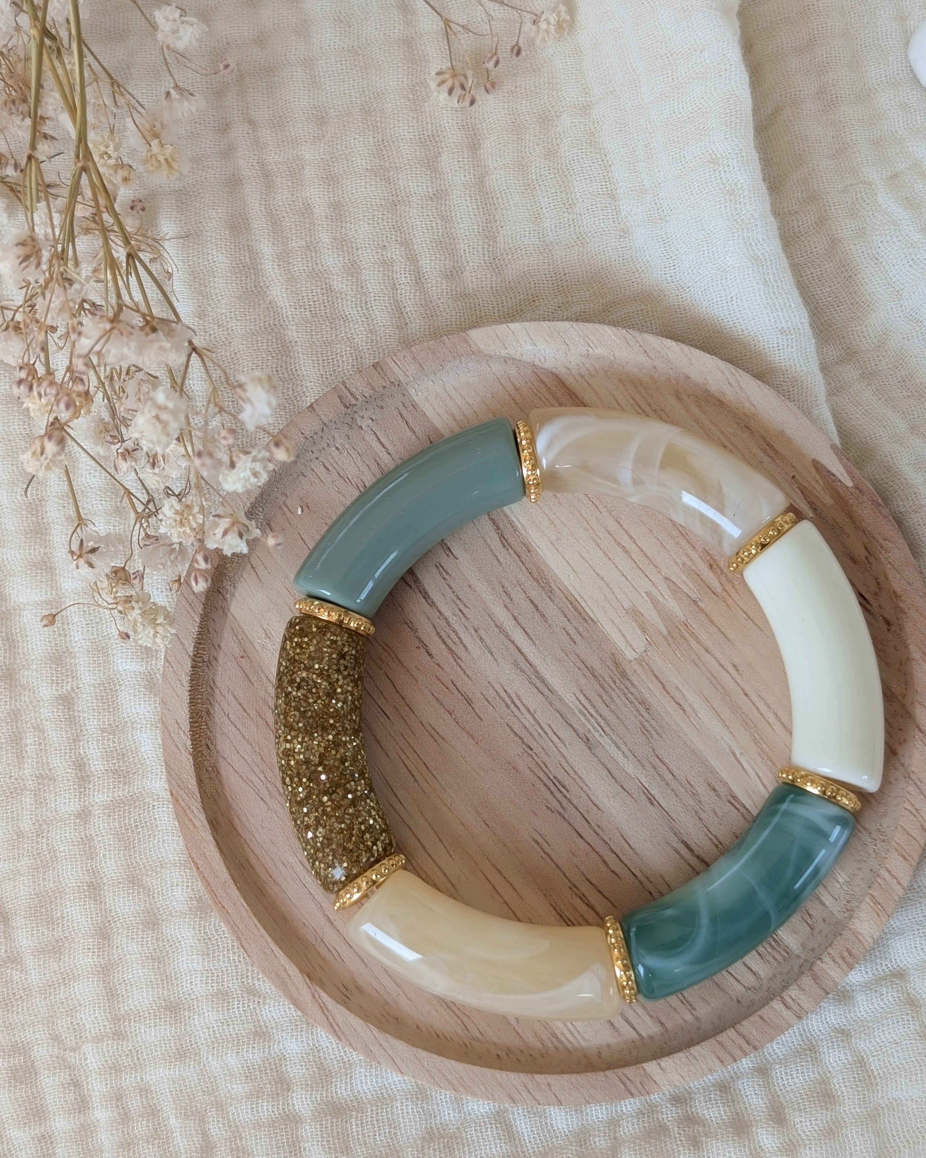 Bracelet perles tube vert pastel marbré et perles intercalaires dorées haute qualité. Sur support en bois. Création La Tête dans les Nétoiles
