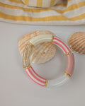 Bracelet perles tube à rayures rose photo en gros plan. et perles intercalaires dorées. Créations La Tête dans les Nétoiles