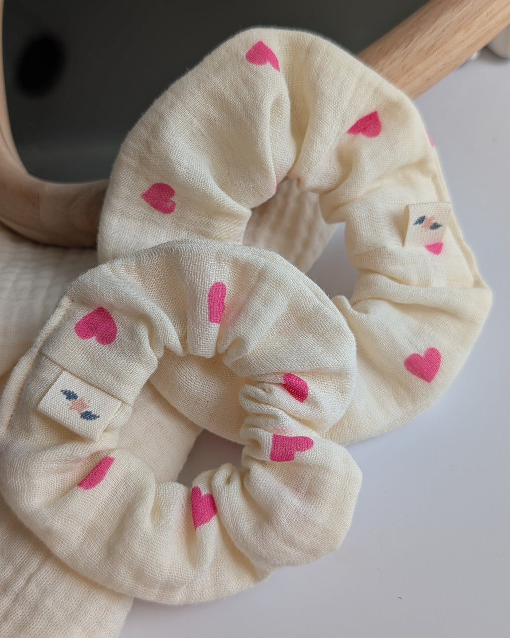 Chouchou gaze de coton écru et coeur rose vif en taille enfant et adulte. Posés à plat. Créations artisanales La Tête dans les Nétoiles