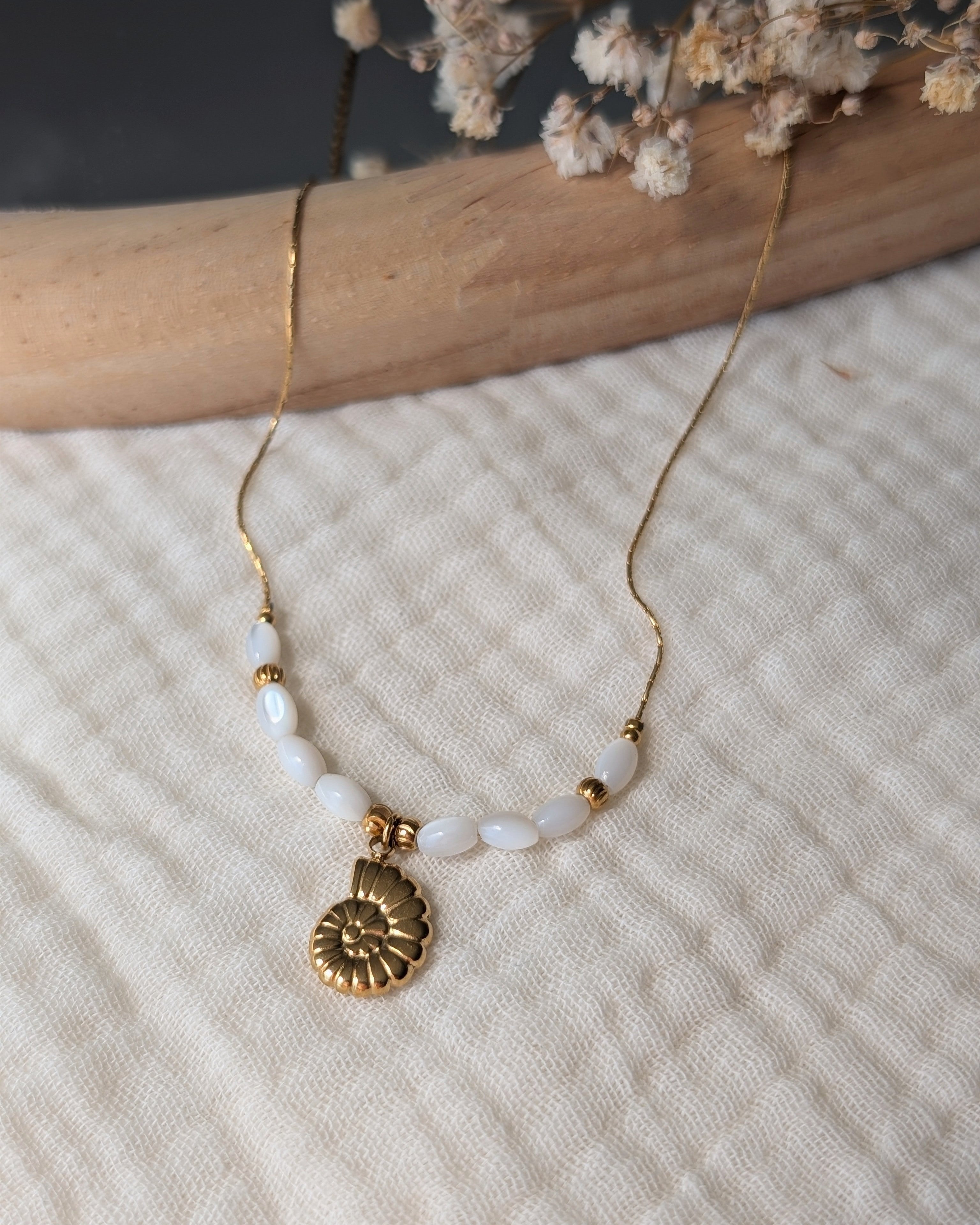 Collier Néri pendentif ammonite posé sur gaze de coton. Création La Tête dans les Nétoiles