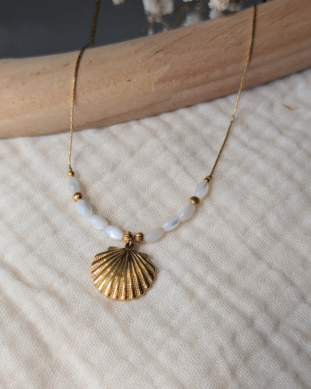 collier Neri pendentif coquillage posé sur gaze de coton. Créations artisanales La Tête dans les nétoiles