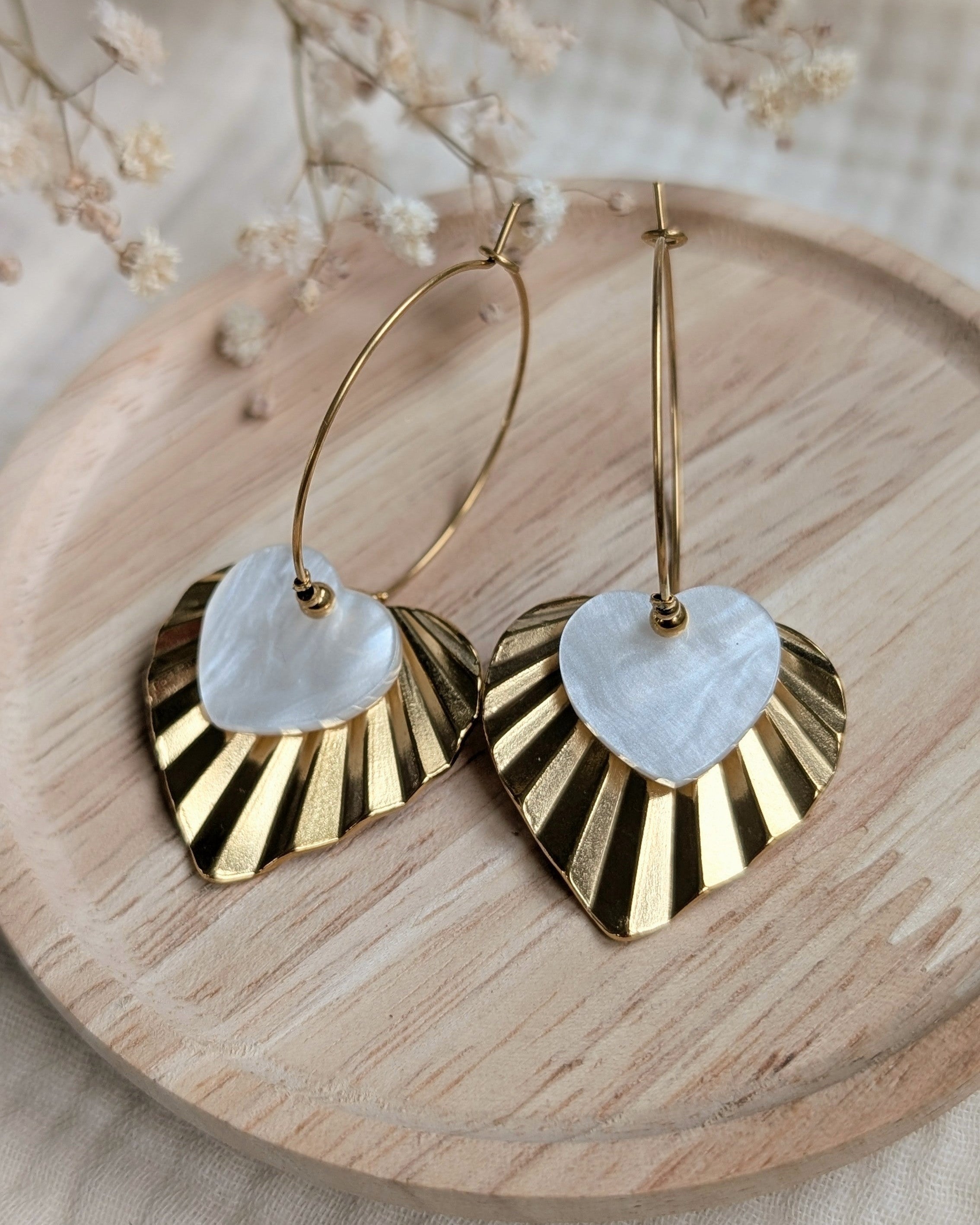 creoles ALMA coeur en acrylique blanc nacre et acier inoxydable sur support en bois et fond fleurs
création artisanale La Tête dans les Nétoiles