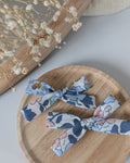 duo barrette cheveux liberty betsy bleu denim posé sur support en bois. Créations cousues La Tête dans les Nétoiles