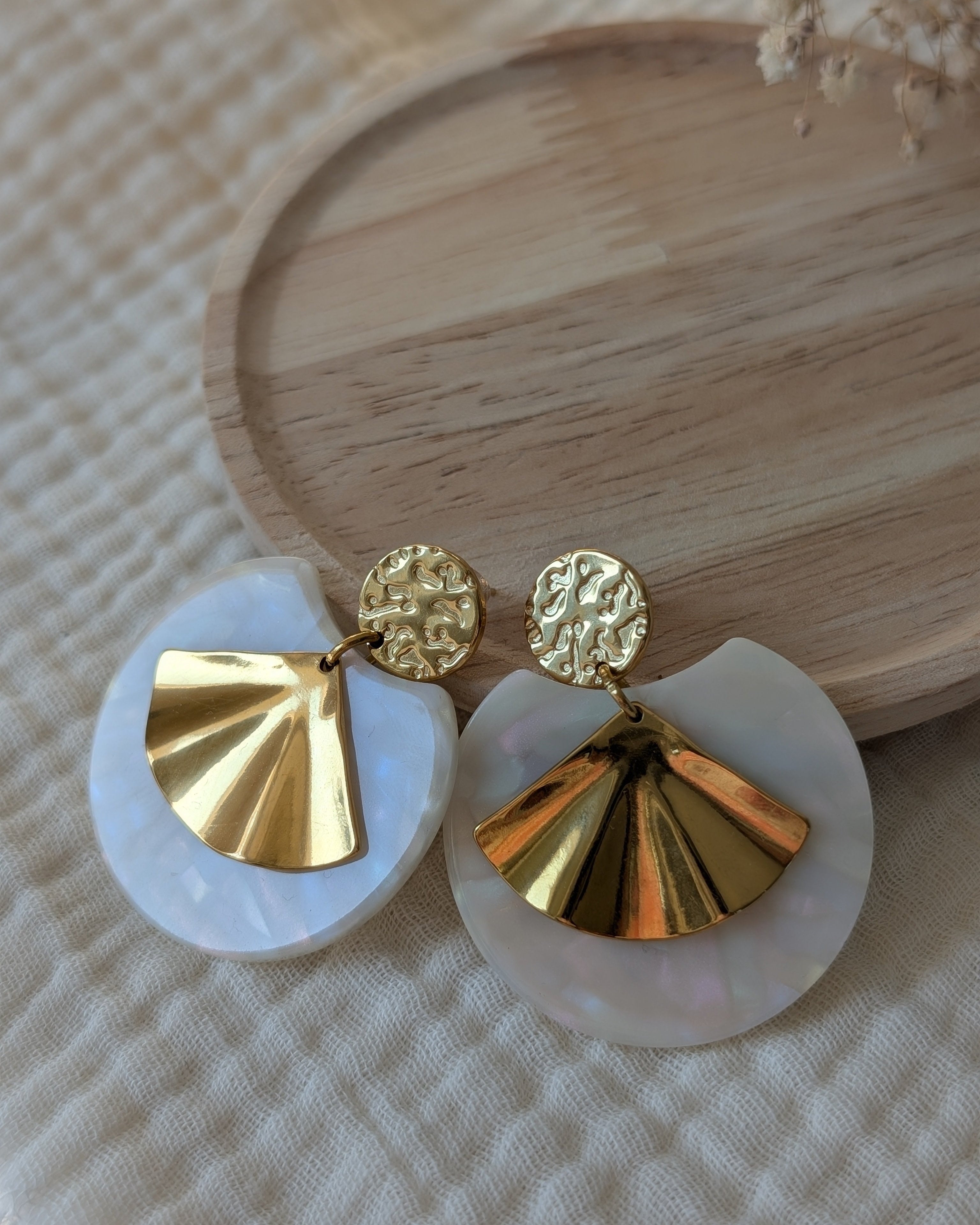 gros plan sur les boucles d'oreilles Zéline . acétate arc en ciel et éventail doré. création La Tête dans les Nétoiles