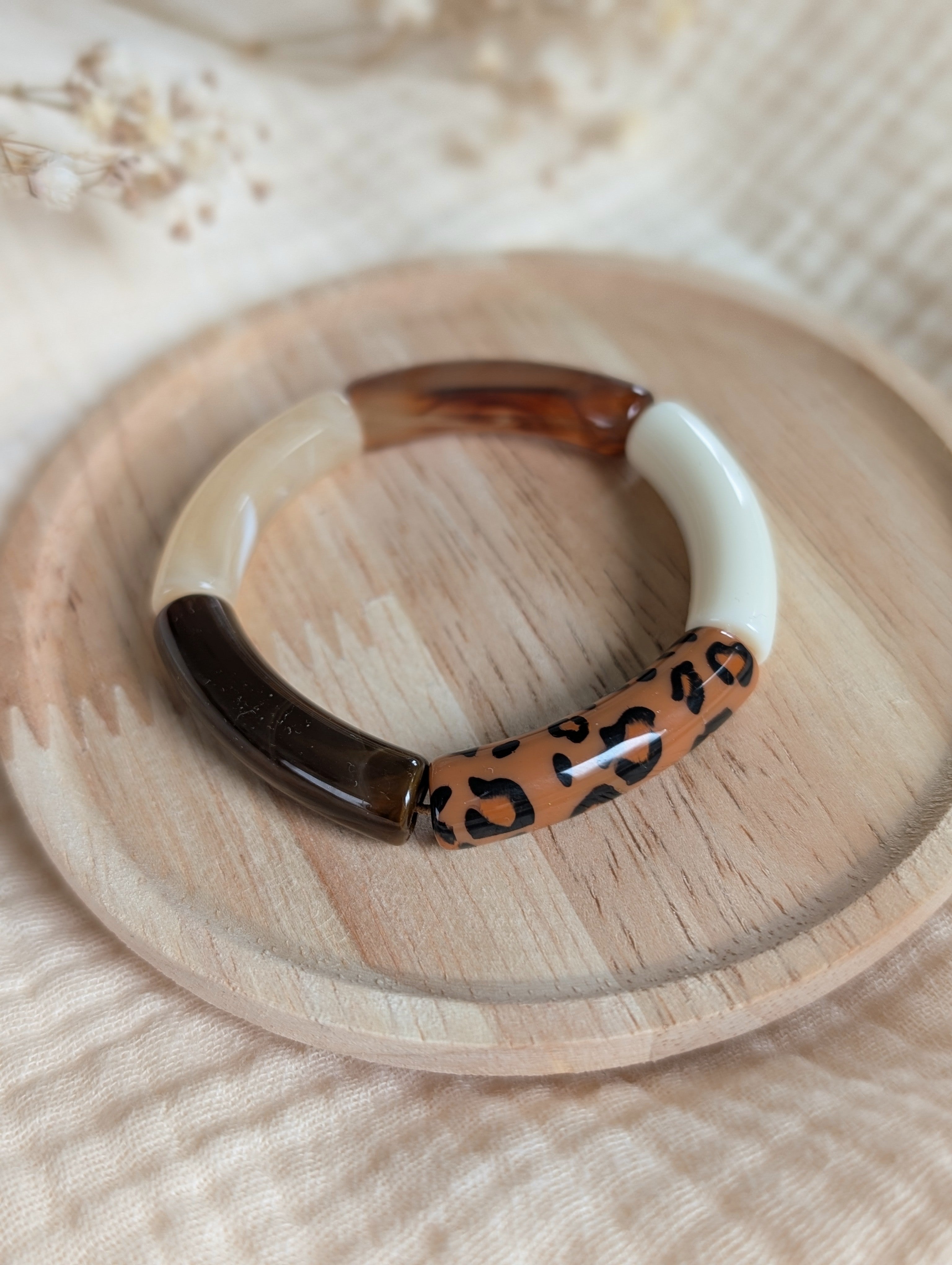 Bracelet LISA MINI perle tube enfant sur support bois tons marron et léopard. Création La Tête dans les Nétoiles photo en gros plan