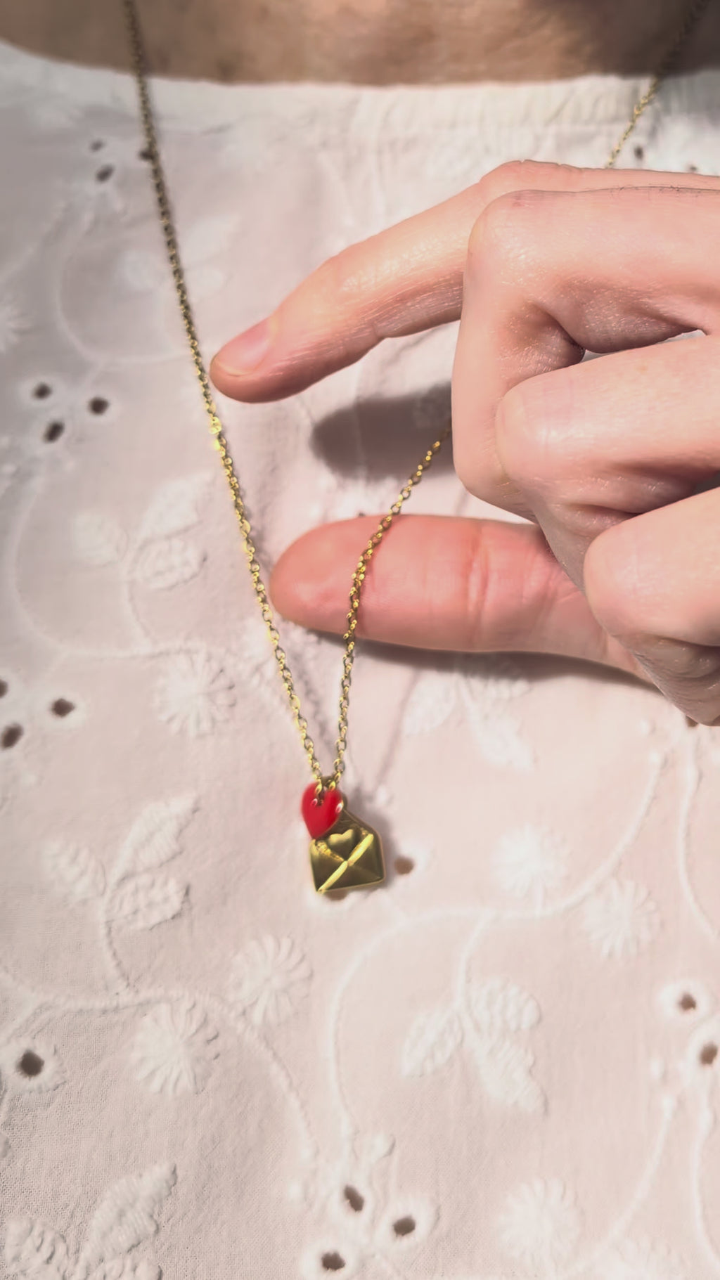 Collier lettre d'amour et coeur rouge epoxy porté sur chemisier blanc