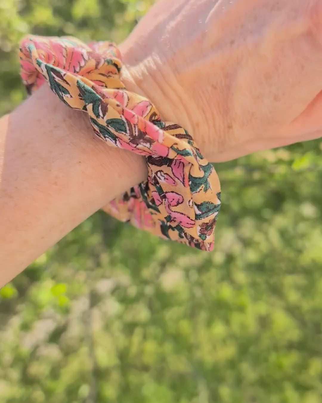 Chouchou floral indien sur fond ocre porté au poignet femme