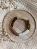 Bracelet enfant Mini Lisa perle tube couleur terracotta écru sur support en bois 