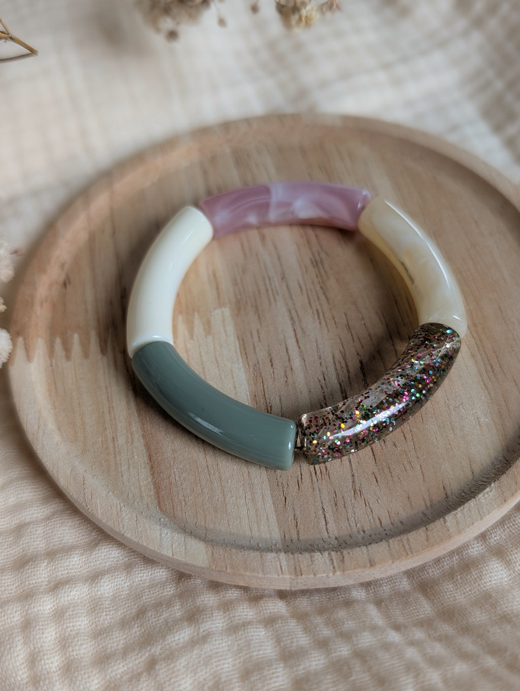Bracelet enfant perles tubes Lisa mini rose vert sauge et perle multicolore à paillettes en gros plan sur support en bois Créations bijou enfant La Tête dans les Nétoiles 