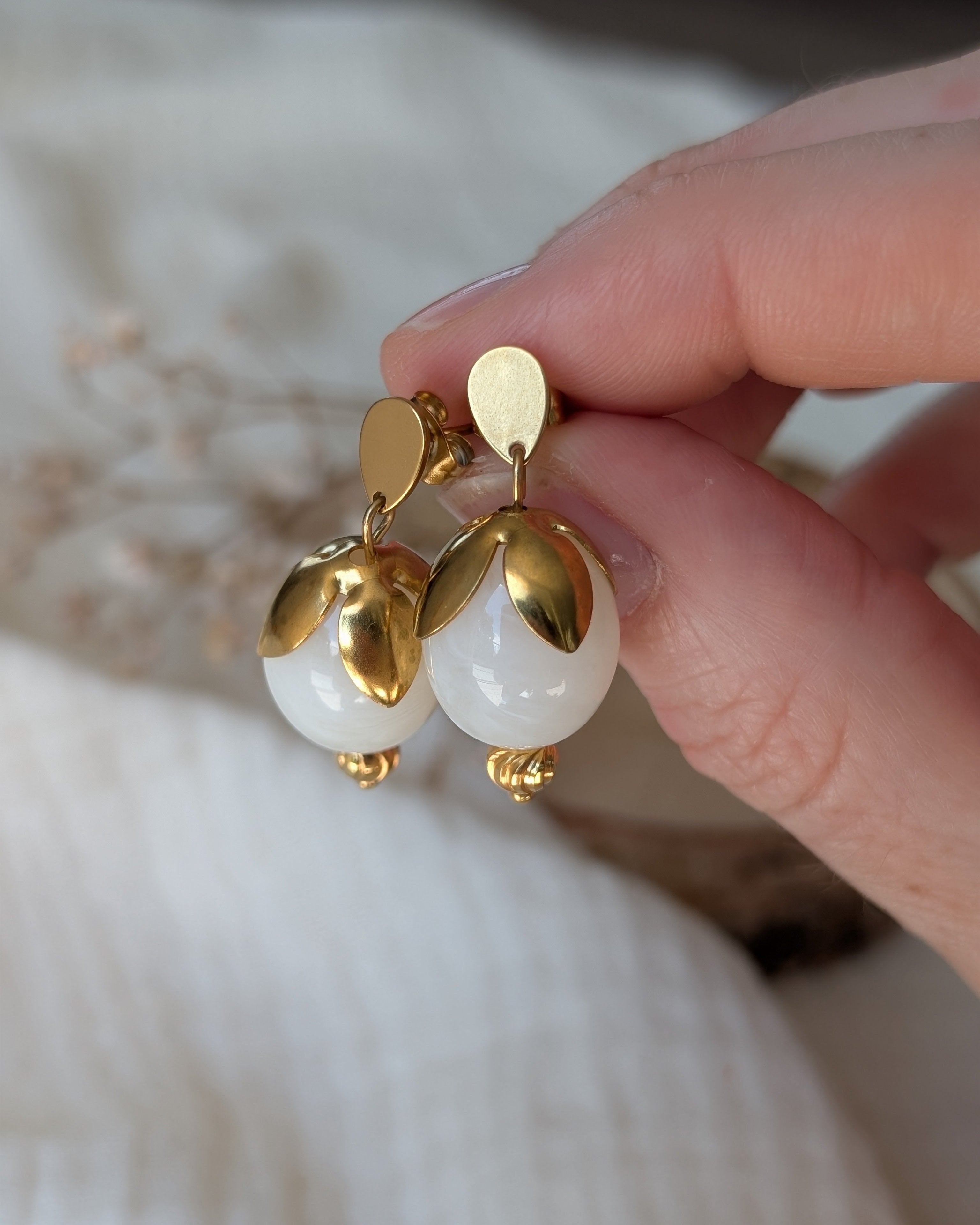 gros plan sur les boucles Olivia perle resine olive en blanc nacré. Créations artisanales La Tête dans les Nétoiles